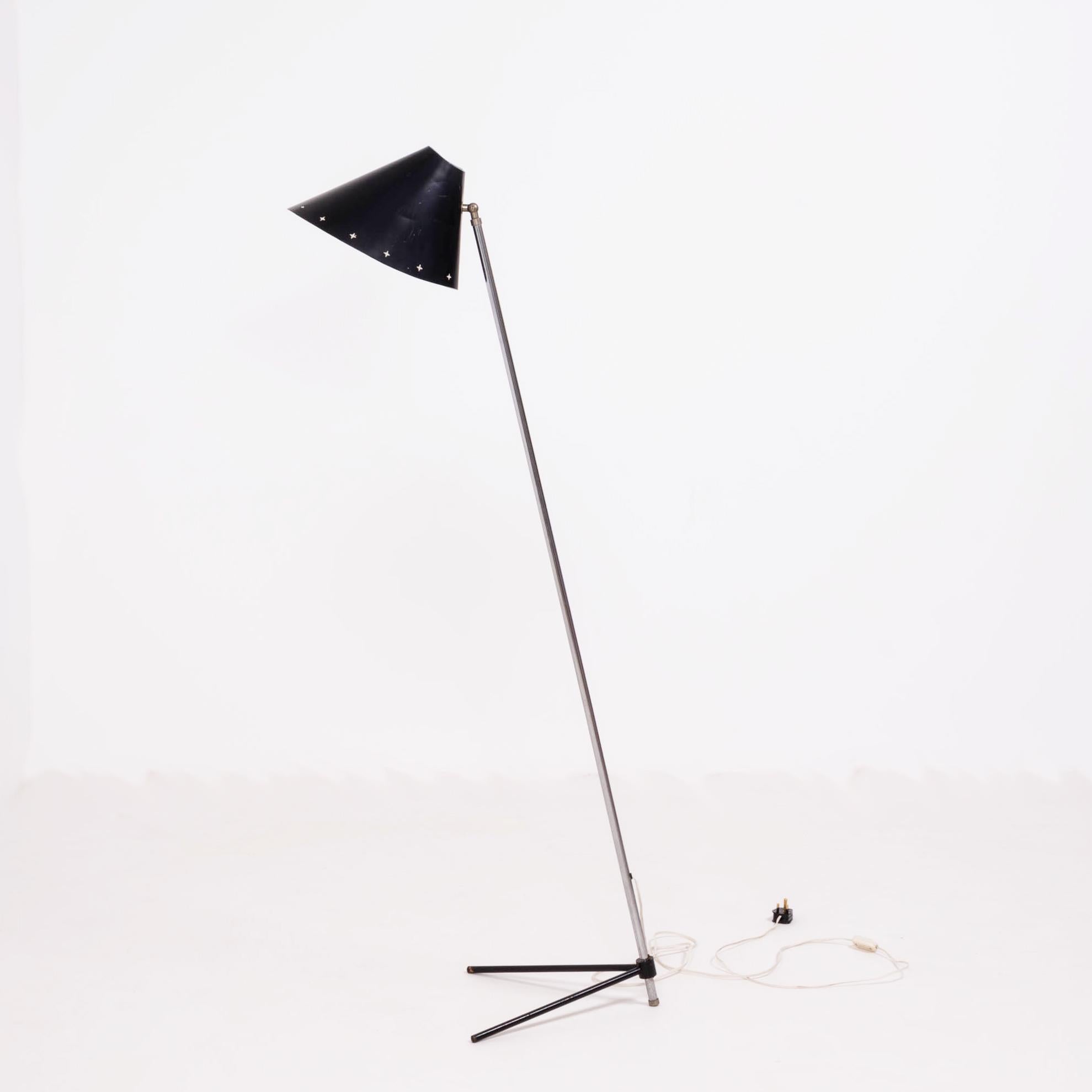 Designed by H. Busquet for Hala Zeist in 1954, this rare Pinocchio floor lamp features a black enamel shade with star-shaped cut-outs around the edge.

The Mid Century lamp has a metal stand with black angled feet, and can be turned on and off with