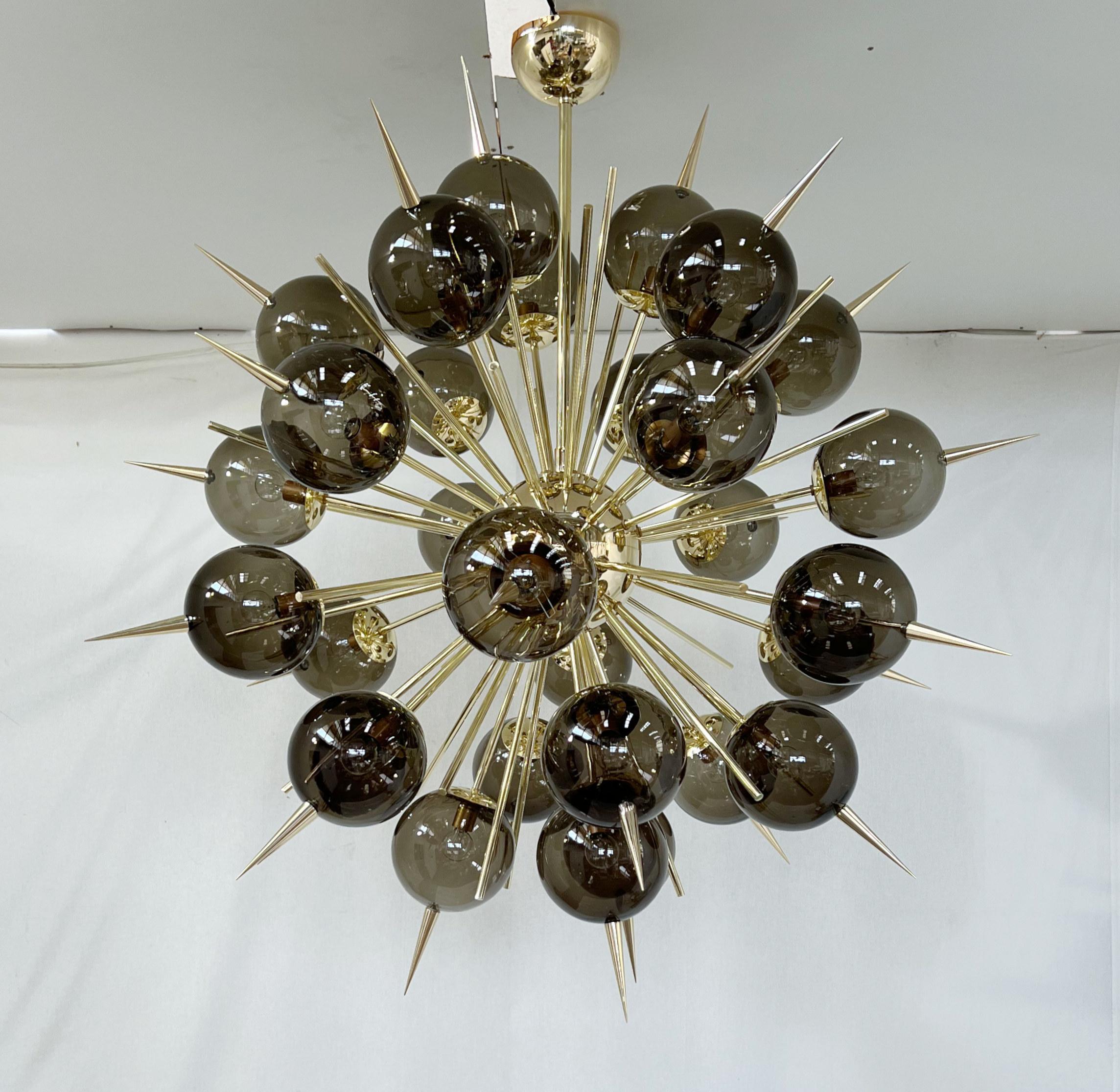 Lampadario sputnik italiano con 30 globi in vetro di Murano e punte in ottone massiccio montate su una struttura in ottone / Disegnato da Fabio Bergomi per Fabio Ltd / Made in Italy
30 luci / tipo E12 o E14 / max 40W ciascuna
Misure: Diametro 47