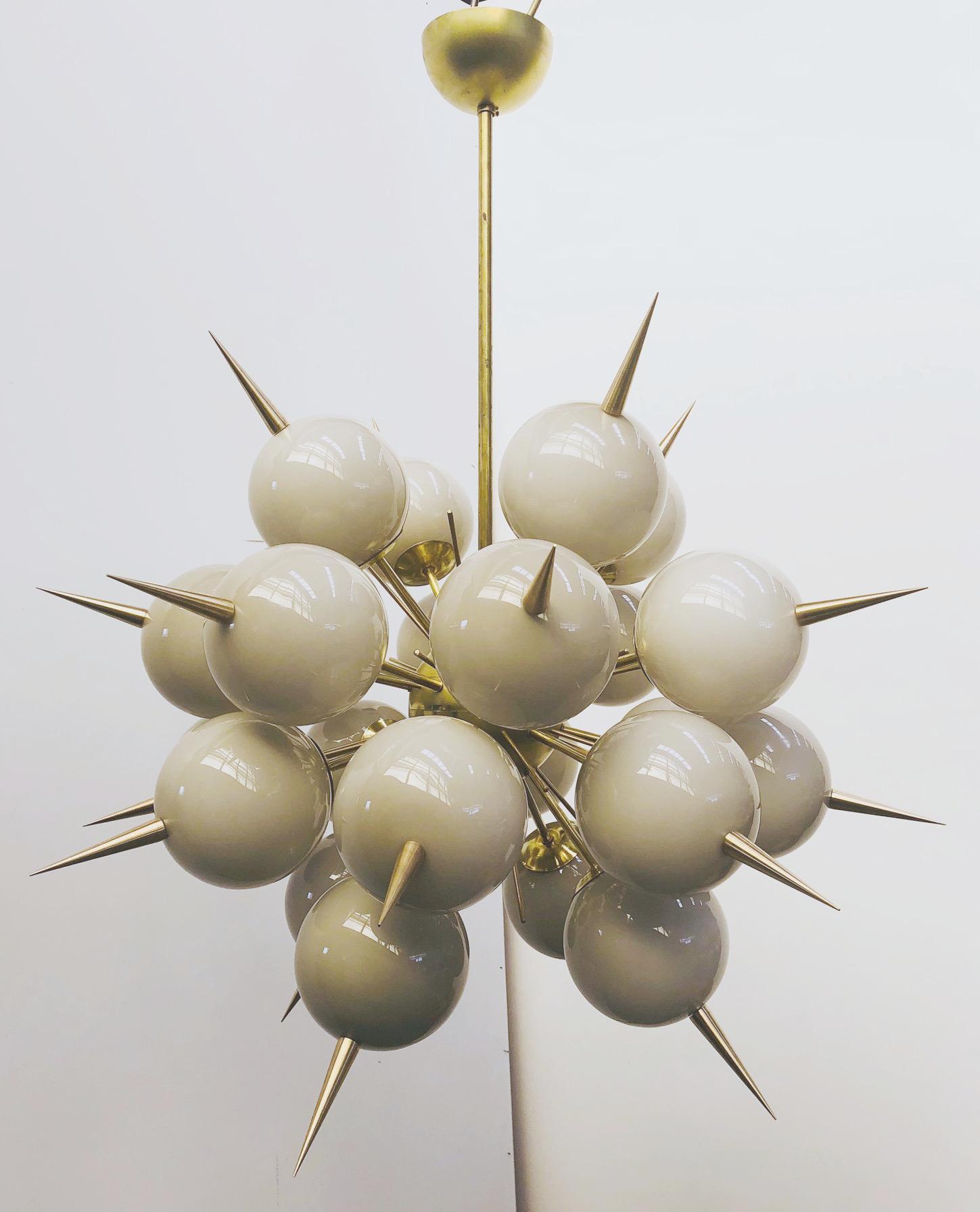 Lampadario sputnik italiano con 24 globi in vetro di Murano e punte in ottone massiccio montate su una struttura in ottone / Disegnato da Fabio Bergomi per Fabio Ltd / Made in Italy
24 luci / tipo E12 o E14 / max 40W ciascuna
Diametro: 38 pollici /