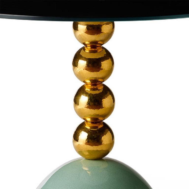 This elegant side table is part of the Pins collection introduced at Milan Design Week 2018. Its elegant silhouette plays with the round shape, creating sinuous volumes accented with different colors. The brass structure supports a glass round top
