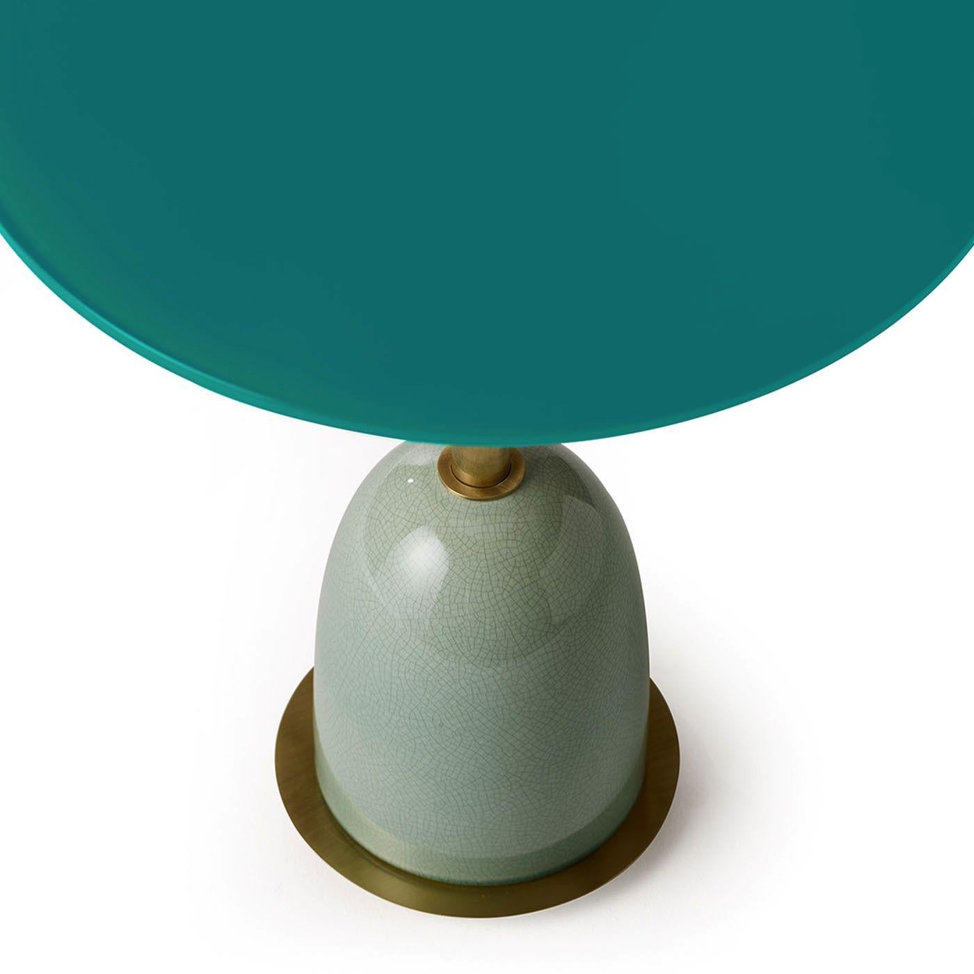 Pins round side table in brass with back painted glass top and ceramic glazed base in contrasting color. Available in different colors and finishes. The side tables of the Notorious collection have been designed with the intention of offering a
