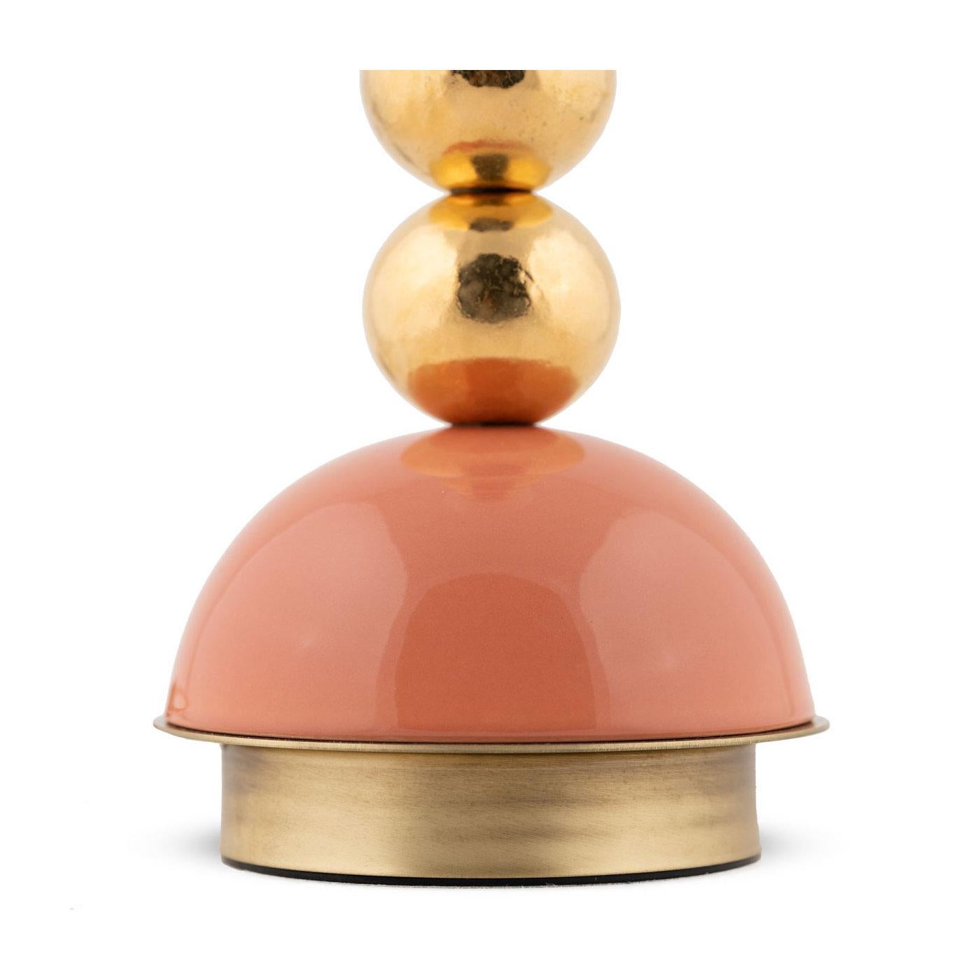 A splendid combination of lines and hues, this table lamp will add a lively accent in any modern interior decor. Resting on a peach-glazed ceramic base mounted on a satin brass plate, the main body is composed of four spherical elements in