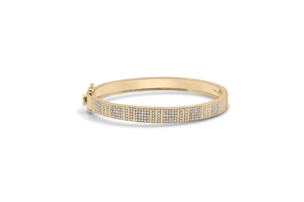 Highly polished 14k yellow gold with hand-set Brilliant Cut diamonds set in a pinstripe pattern define this bold and glamorous knife edge bracelet. With its bold and sturdy feel, this collection symbolizes strength and power. This stackable bracelet
