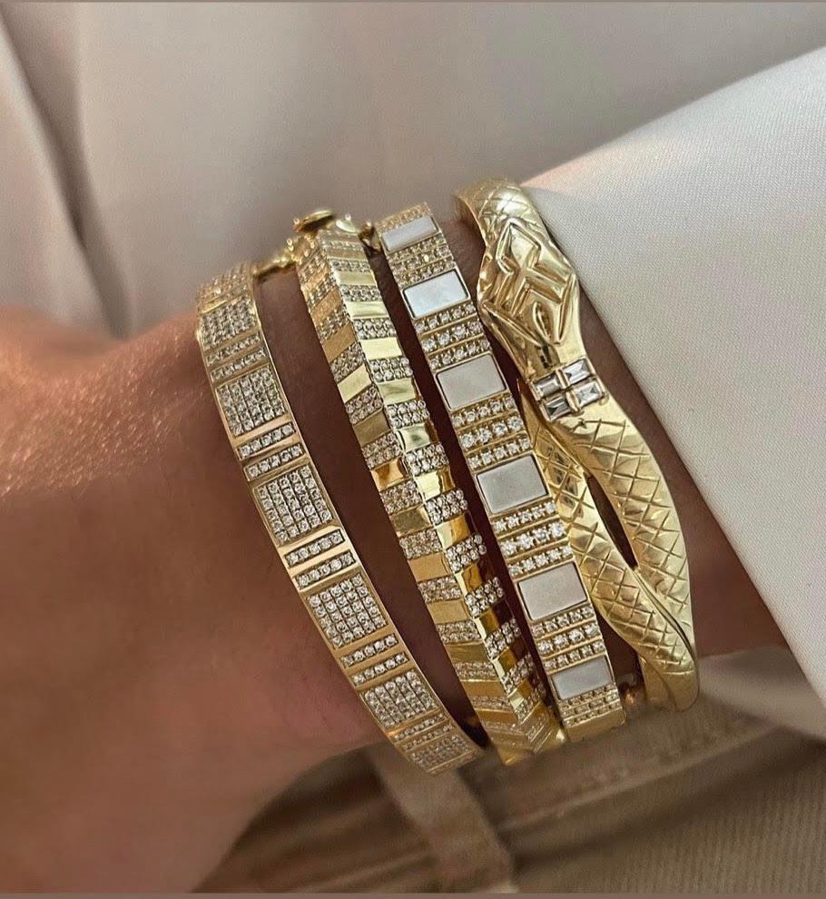 Highly polished 18k yellow gold with hand-set Brilliant Cut diamonds set in a pinstripe pattern define this bold and glamorous knife edge bracelet. The CHUBBY version of the kniefeedge pinstripe bangle has an added glamorous feel. With its bold and