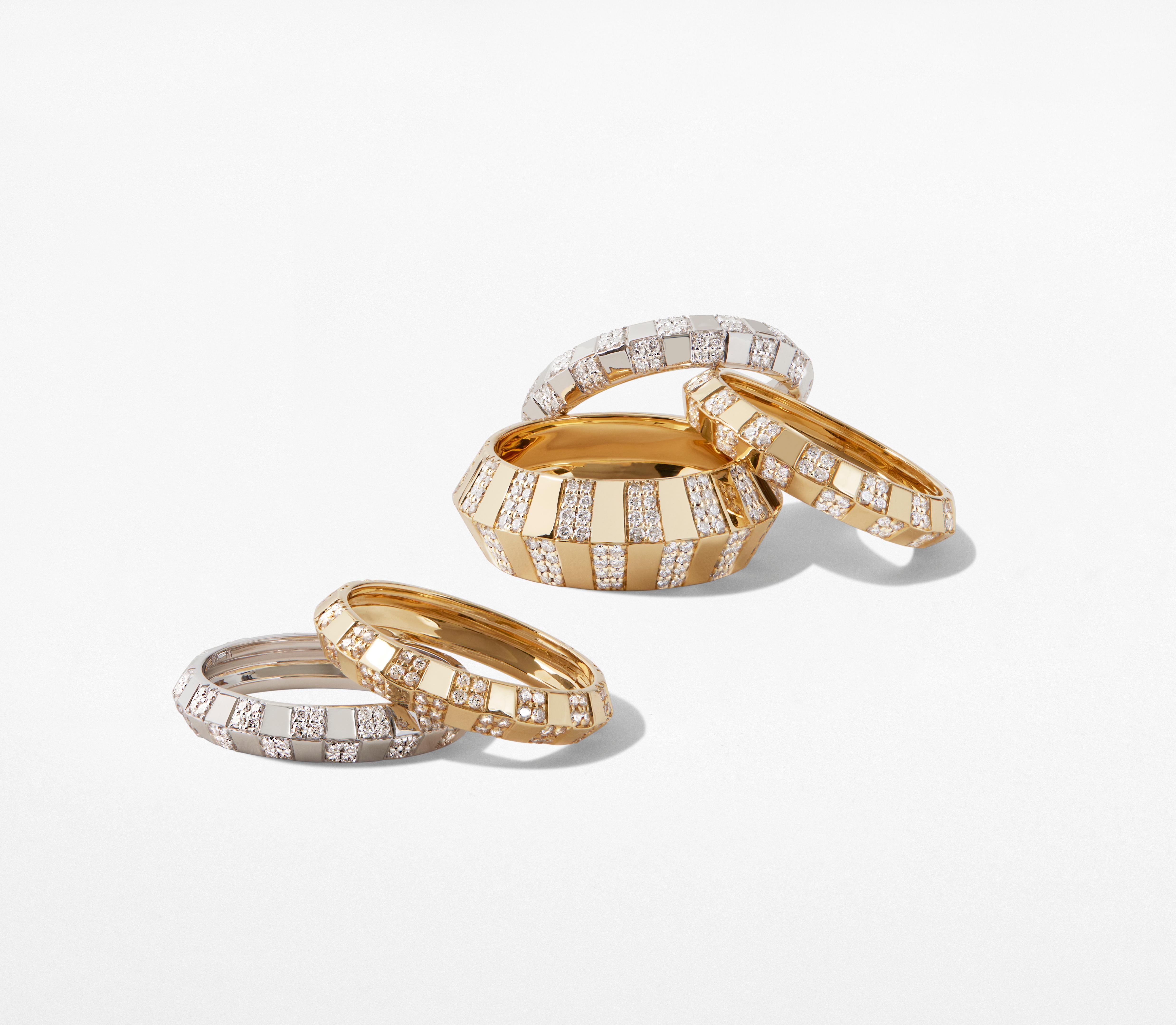 Highly polished 18k yellow gold with 112 hand-set Brilliant Cut diamonds set in a pinstripe pattern define this bold and glamorous  knife edge ring. With its bold and sturdy feel, this collection symbolizes strength and power. This stackable ring