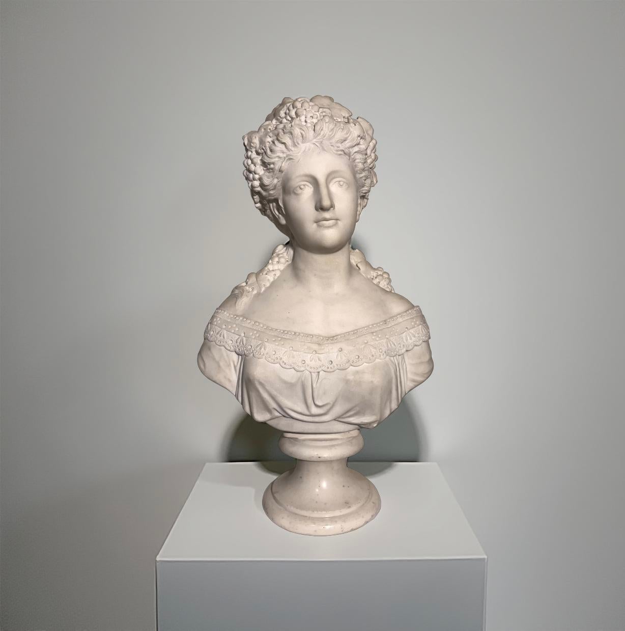 Grand buste en marbre blanc de Carrare représentant une jeune femme aux cheveux ornés de feuilles et de grappes de raisin, signé 