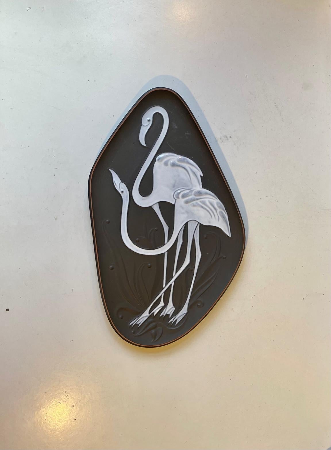 A stylish asymmetrical organically shaped dish or wall plaque decorated with a pair of Flamingos in white glaze. Designed by Piotr Labuzek Baro and made at Knabstrup in Denmark circa 1960. It can be wall hung or displayed as a dish. Measurements: