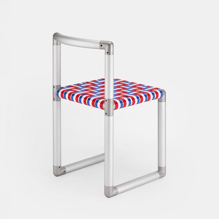 Assembled from aluminum piping and steel connectors, the tubular frame provides a sturdy structure versatile for indoor and outdoor use. The customizable webbing seat allows for a personalized touch, offering both comfort and style to suit any