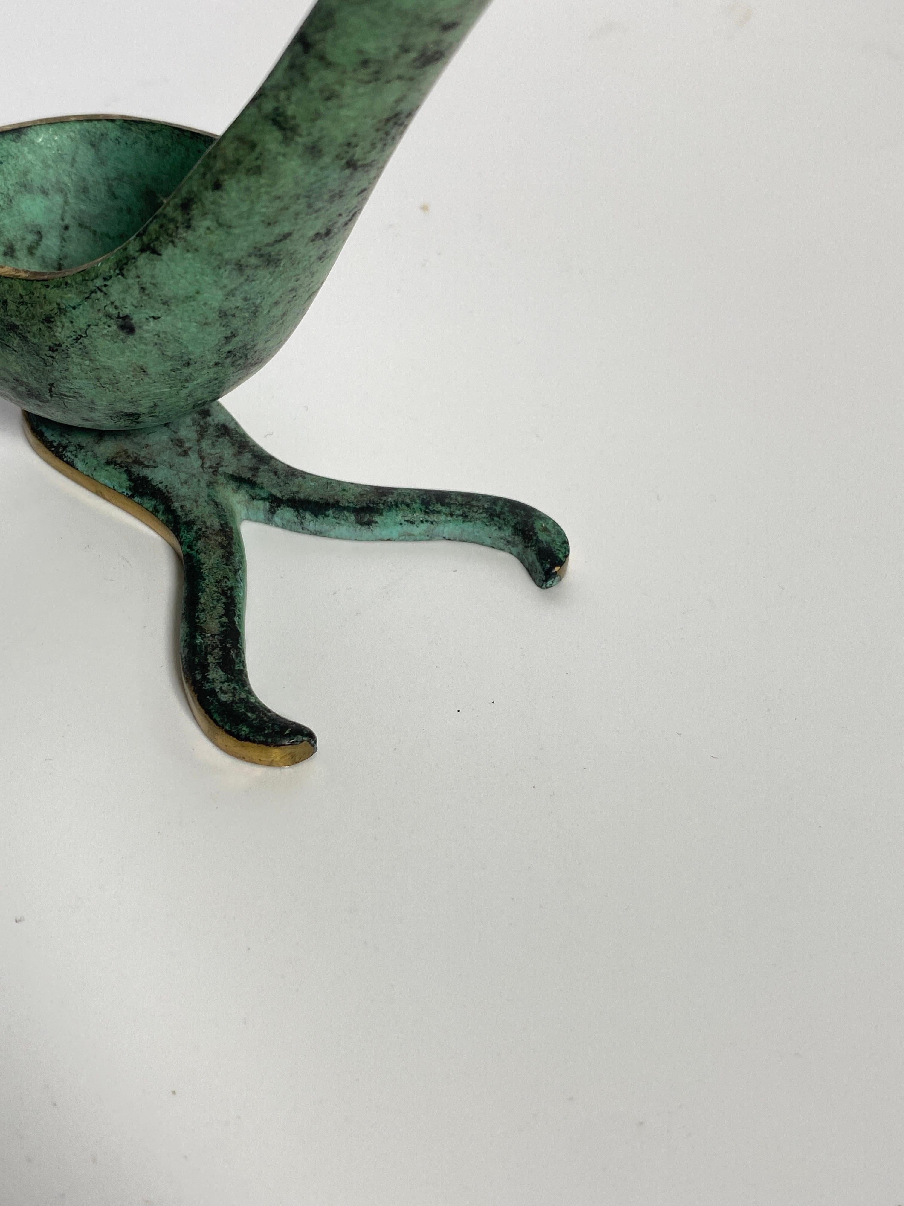 It is a pipe holder, in patinated bronze in green and gold color. This pipe holder was made in USA in the 1960s by Walter Bosse It is in good condition, and is easily placed on a piece of furniture, and also looks like a decorative object.