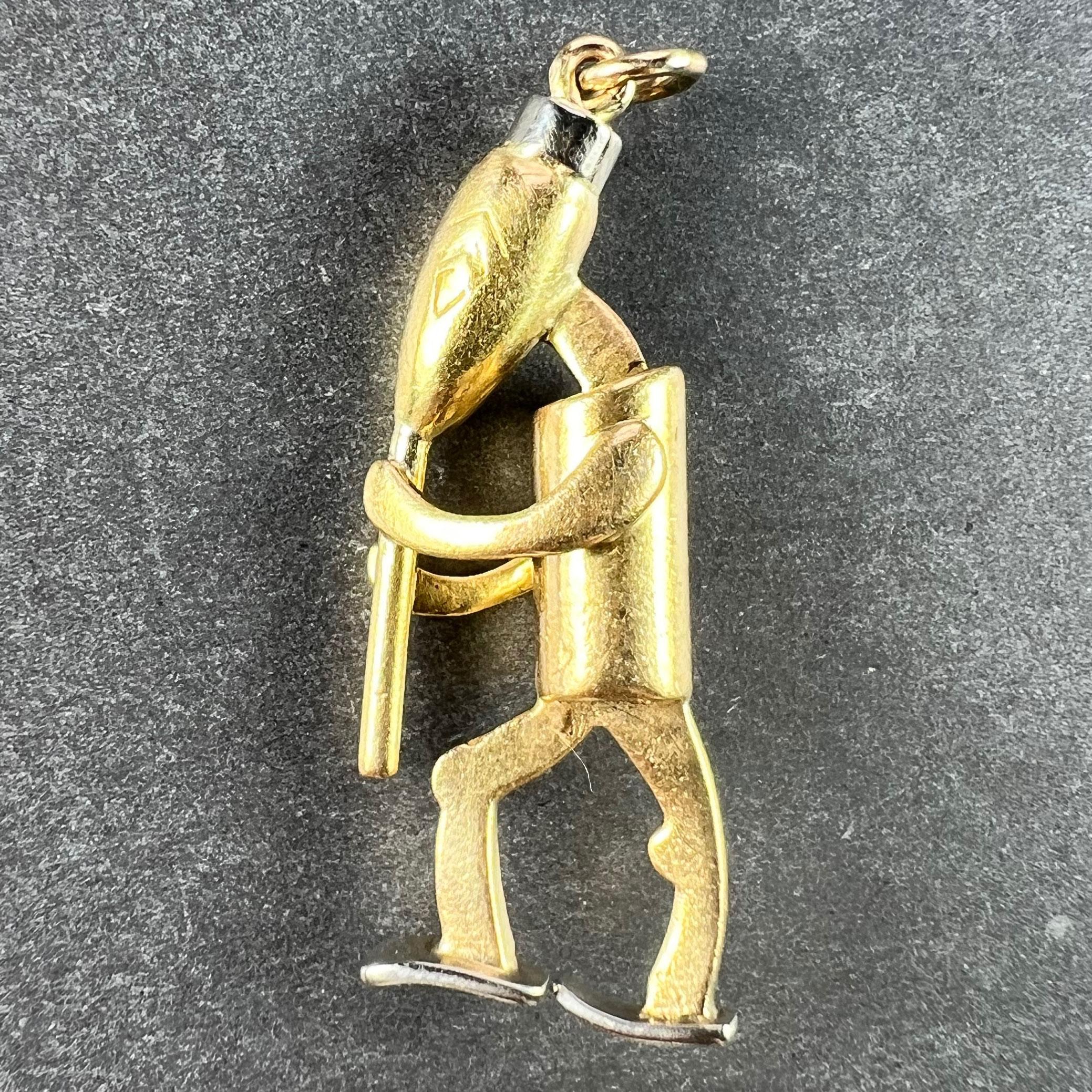 An 18 karat (18K) yellow and white gold charm pendant designed as a cartoon character of a piper or musician playing the pipe, clarinet, recorder or similar musical instrument. Unmarked but tested for 18 karat gold. 

Dimensions: 3.2 x 2.2 x 0.8 cm