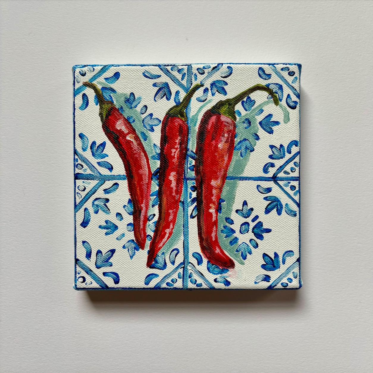 Dieses zeitgenössische Stillleben zeigt drei scharfe Chilischoten auf blauen und weißen mediterranen Fliesen. Diese Leinwand ist Teil meiner MINI Tiles-Serie und kann ungerahmt aufgehängt werden. Inspiriert von der Küche meiner Abuela zu