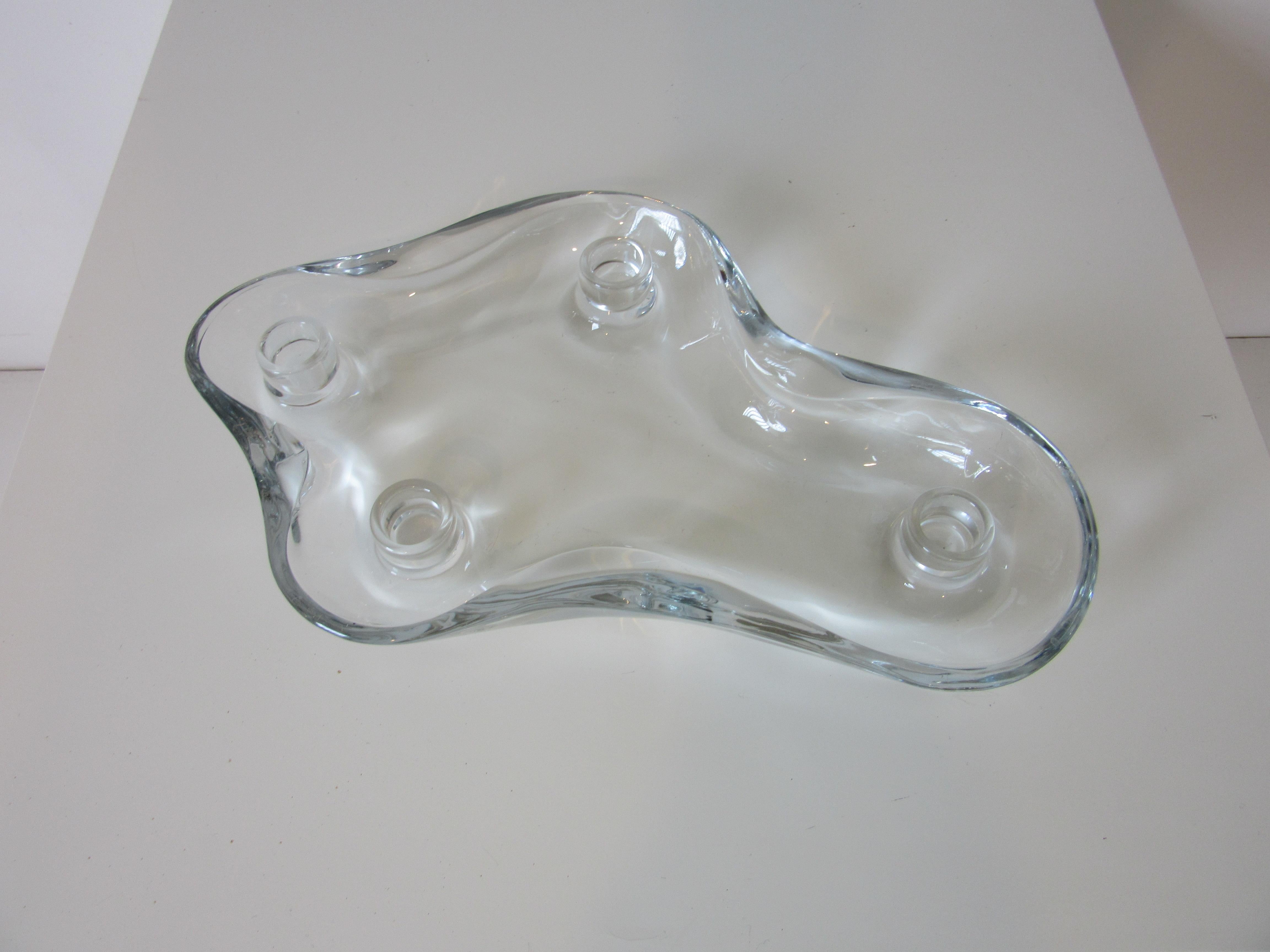 A biomorphic sculptural thick glass flower floater and candleholder designed by Pipsan Saarinen Swanson from the famous Saarinen family daughter of Eliel and sister to Eero Saarinen. She started her career then moved on to working with her husband