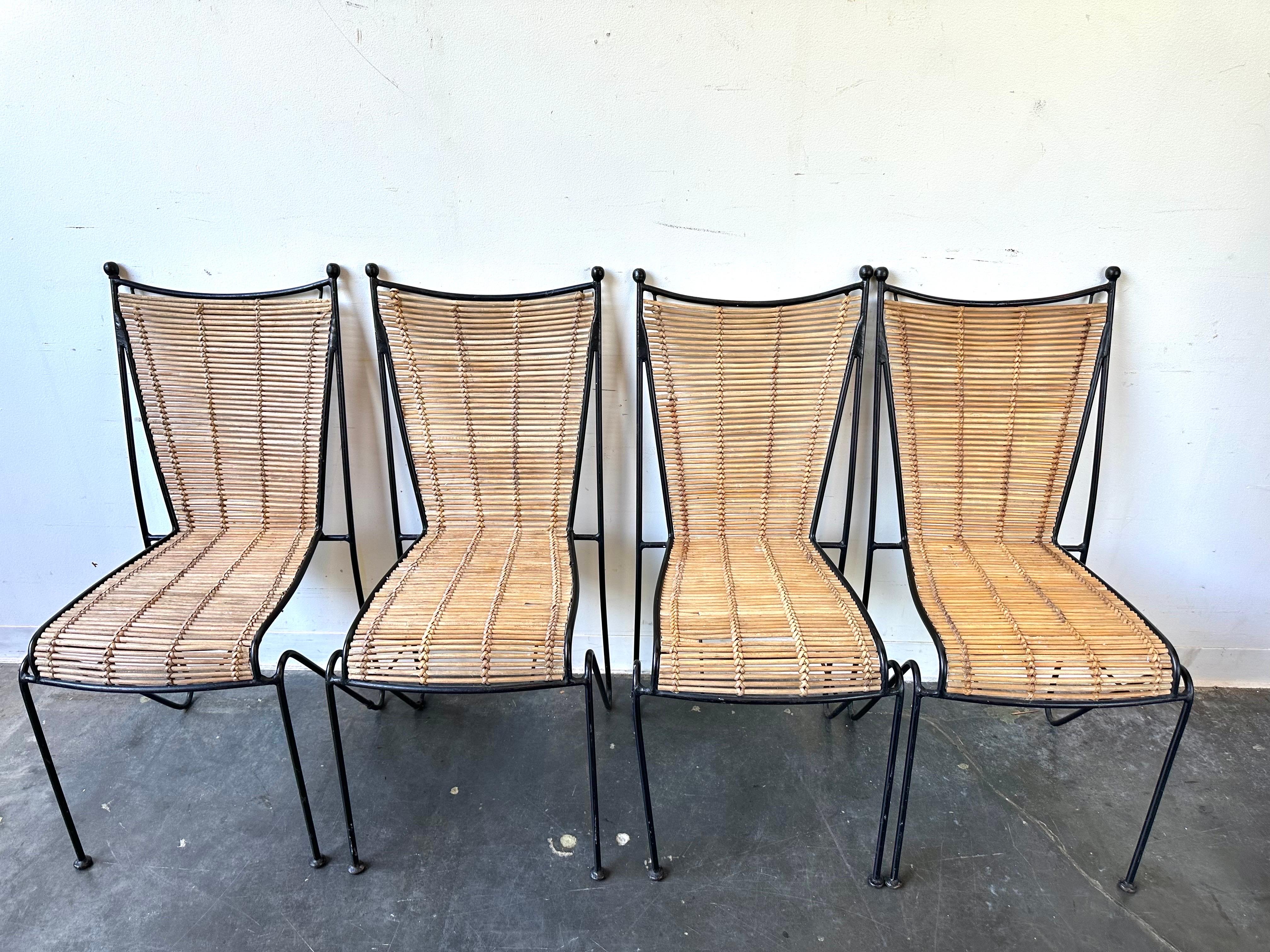 Set of 4 wrought iron and rattan side or dining chairs by Pipsan Saarinen Swanson for Ficks Reed, circa 1960s. Gorgeous silhouette. Excellent design and exquisite craftsmanship. 