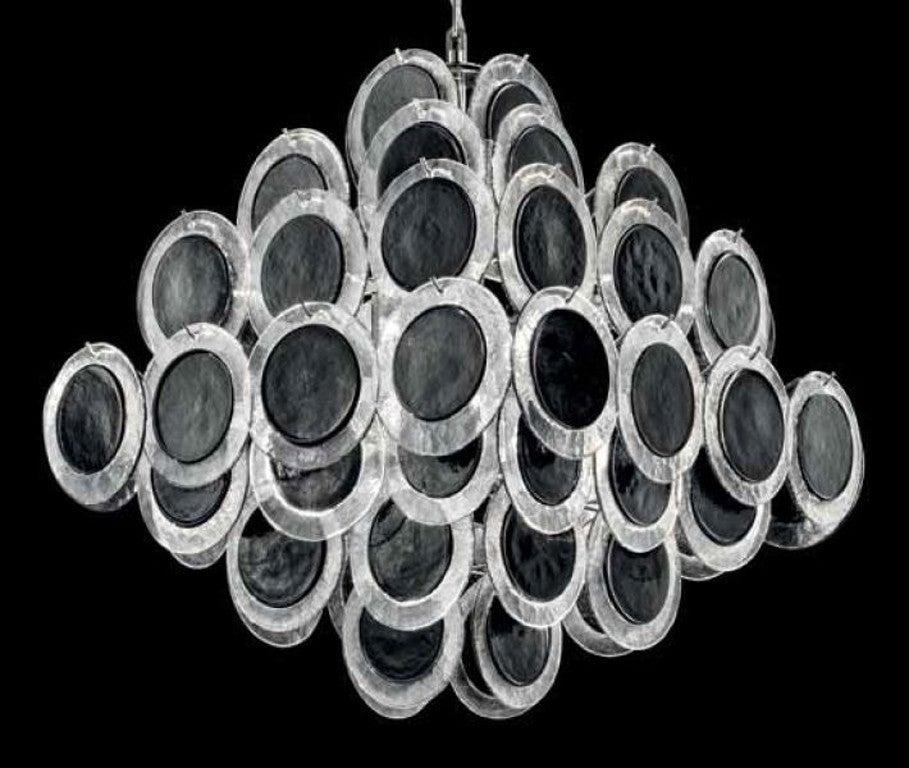 Italienischer Kronleuchter mit Muranoglasscheiben in schwarzer Farbe mit klaren Rändern auf Chromrahmen von Fabio Ltd / Made in Italy
10 Leuchten / Typ E26 oder E27 / max. 60W pro Stück
Maße: Länge 24 Zoll / Breite 24 Zoll / Höhe 24 Zoll plus Kette