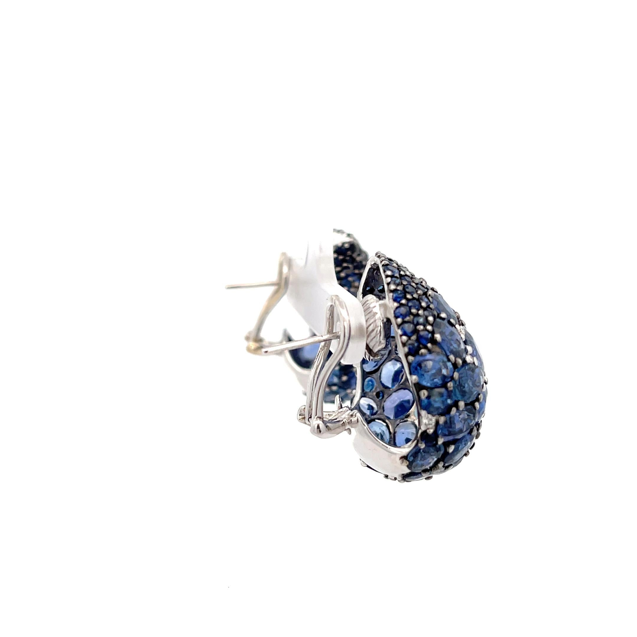 Piranesi Paisley Mosaique Blue Sapphire & Diamond Earrings 18K White Gold. The earrings feature 36ctw of oval and round cut sapphires and 0.13ctw of  brilliant round diamonds. Omega backs with collapsible posts. The earrings have a dimension of  1