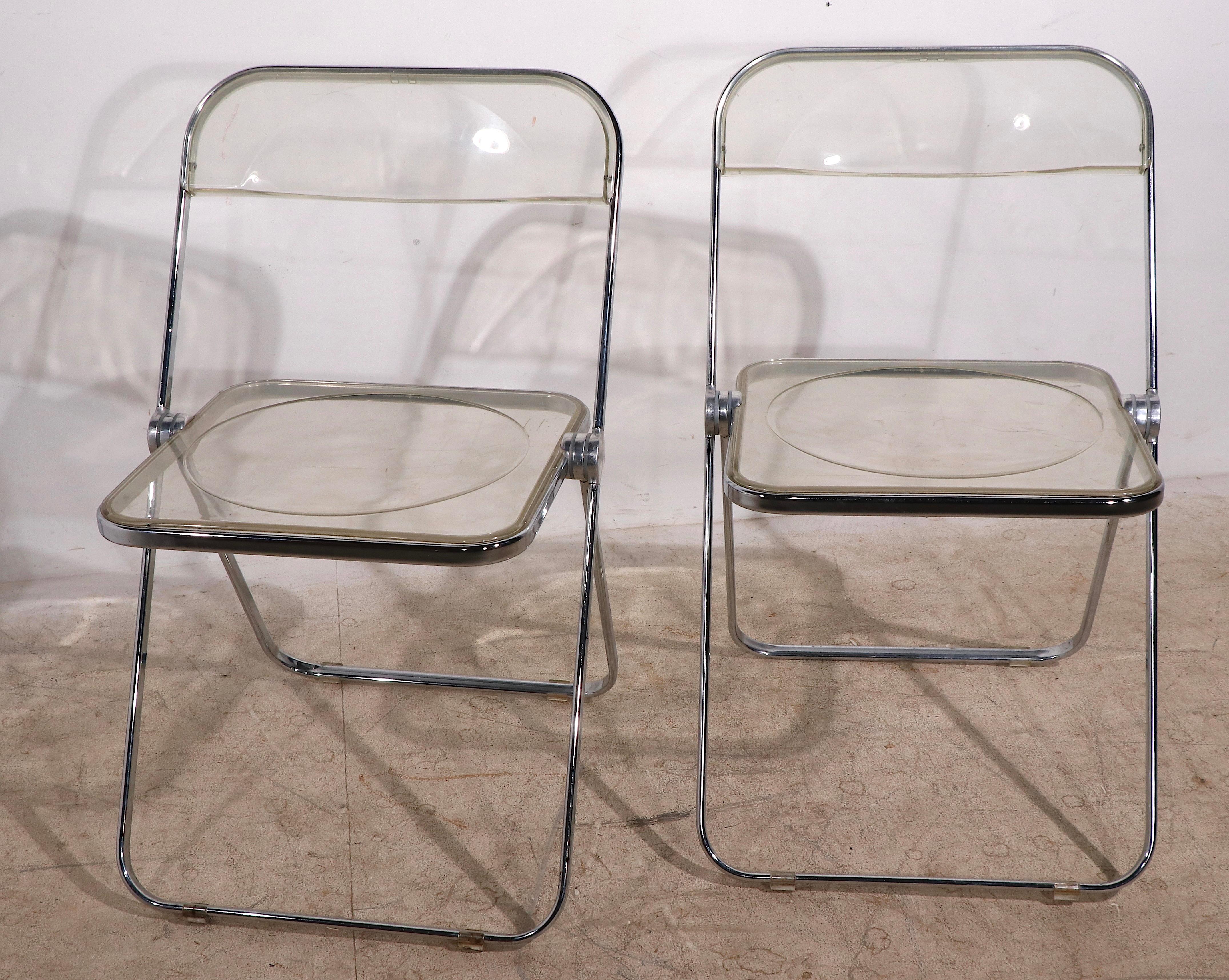 Iconic pair of Italian made Post Modern, Space Age folding chairs, comprised of lucite and aluminum. Both are in very good, original condition, and both are fully and correctly marked ( Plia Castelli ). This timeless design still feels modern, and