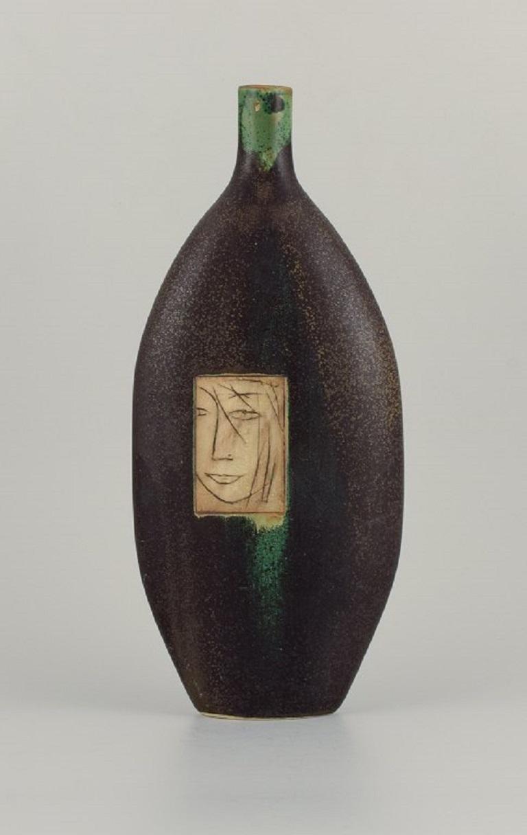 Pirjo Nylander, Finnish ceramist. Unique tall ceramic vase with motif of a woman's face.
circa. 1960s/70s.
Signed.
In excellent condition.
Dimensions: H 37.0 x W 16.0 cm.


.