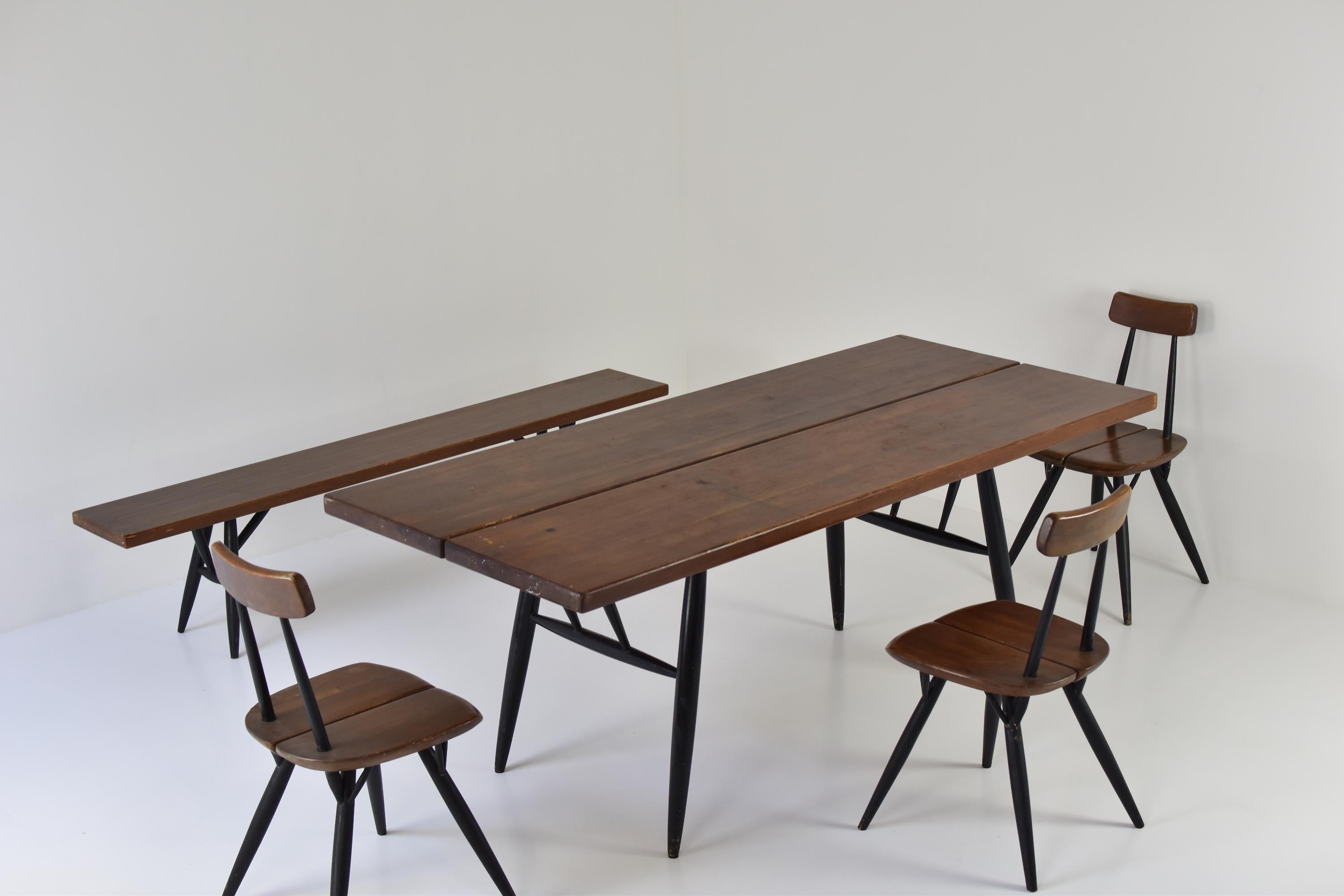 Pirkka dining set by Ilmari Tapiovaara for Laukaan Puu, Finland, 1955. This set features a table, bench and three chairs, all in dark pine and black stained pine wood. Visible signs of age and use. Highly collectible. Labeled.

Dimensions:
Table: H
