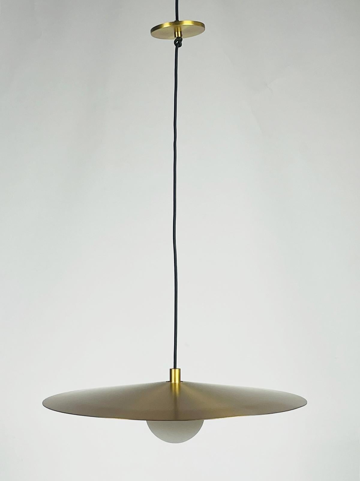 The Pirlo pendant by Sean Lavin for Tech lighting contrasts a flattened metal shade with a frosted glass globe, creating the quintessential Mid-Century modern look. The metal shade directs light downward for illuminating surfaces. The shade is