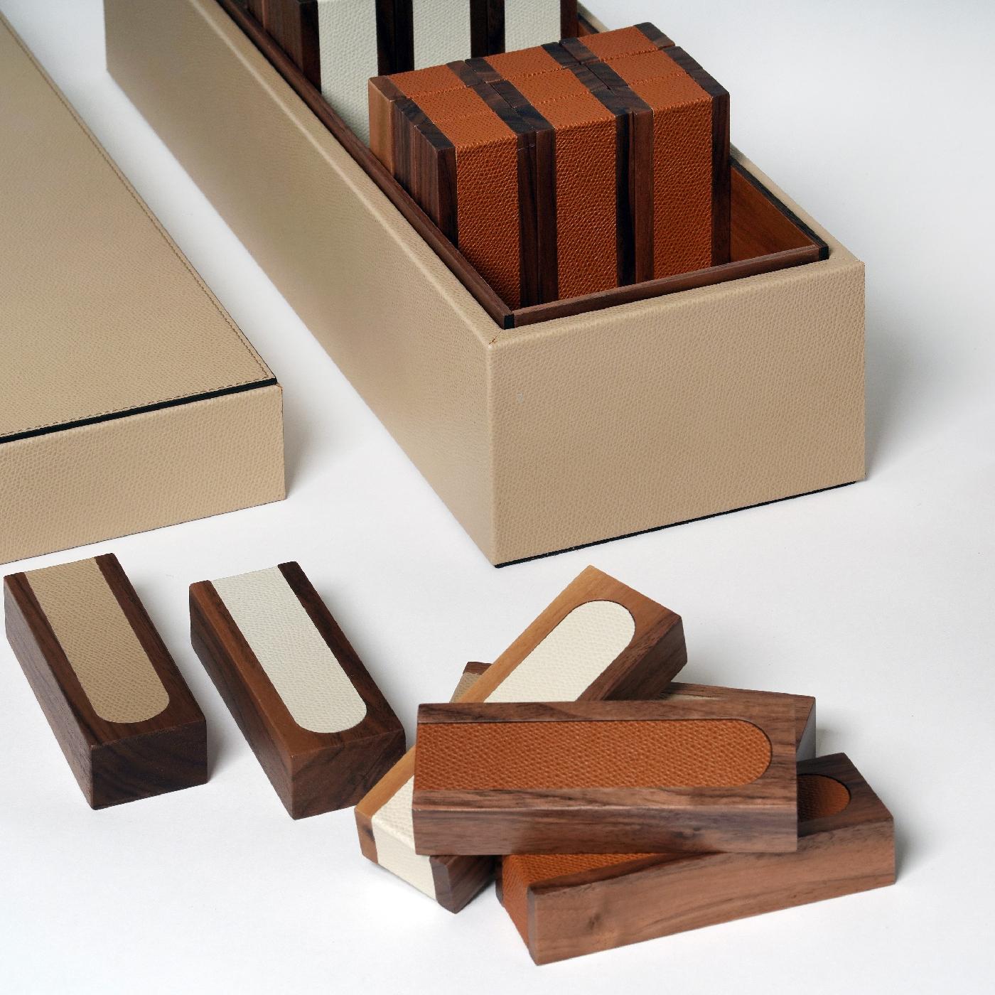 Compact, elegant, and functional, this captivating box set is an iconic board game that will be a timeless addition to a living room decor. The 54 pieces are crafted of Canaletto walnut accented with biege, white, and red lateral leather bands. The