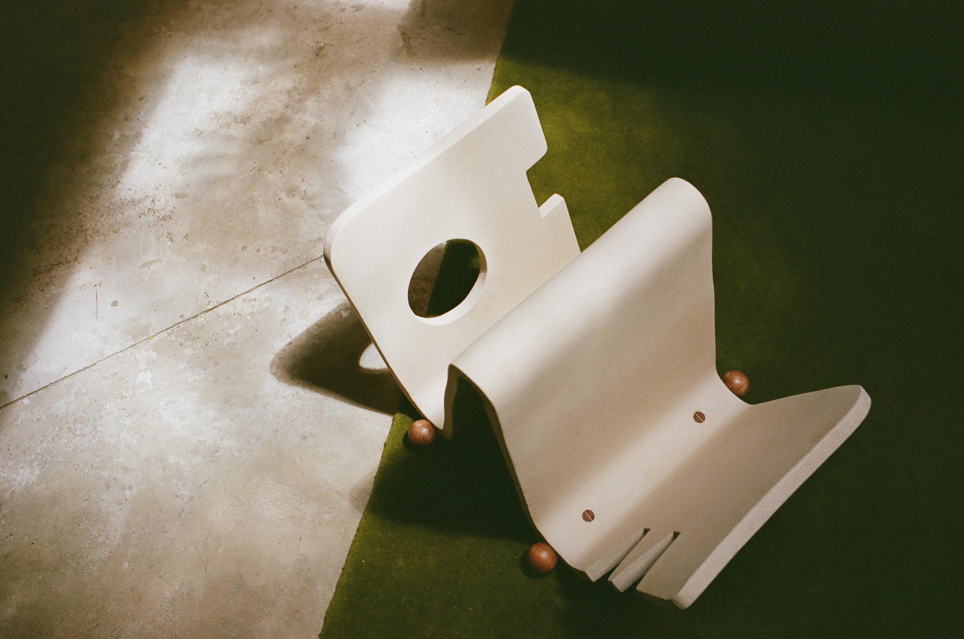 Hand-formed and carefully carved from a single slab of clay, the Piscina Magazine Holder brings a sculptural presence to any space. Designed with a balance of elegance and playfulness, its solid wooden feet tenon through the ceramic base, creating a