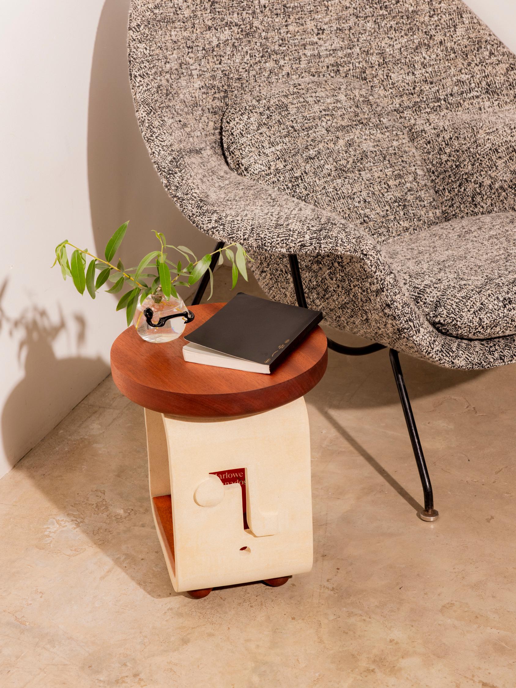 The Reader Side Table Mini in ceramic and wood is formed from a single slab of clay. The wooden table top, feet, and lower table join together with tendons through the ceramic base to create an honest and effortlessly piece making a playful union of