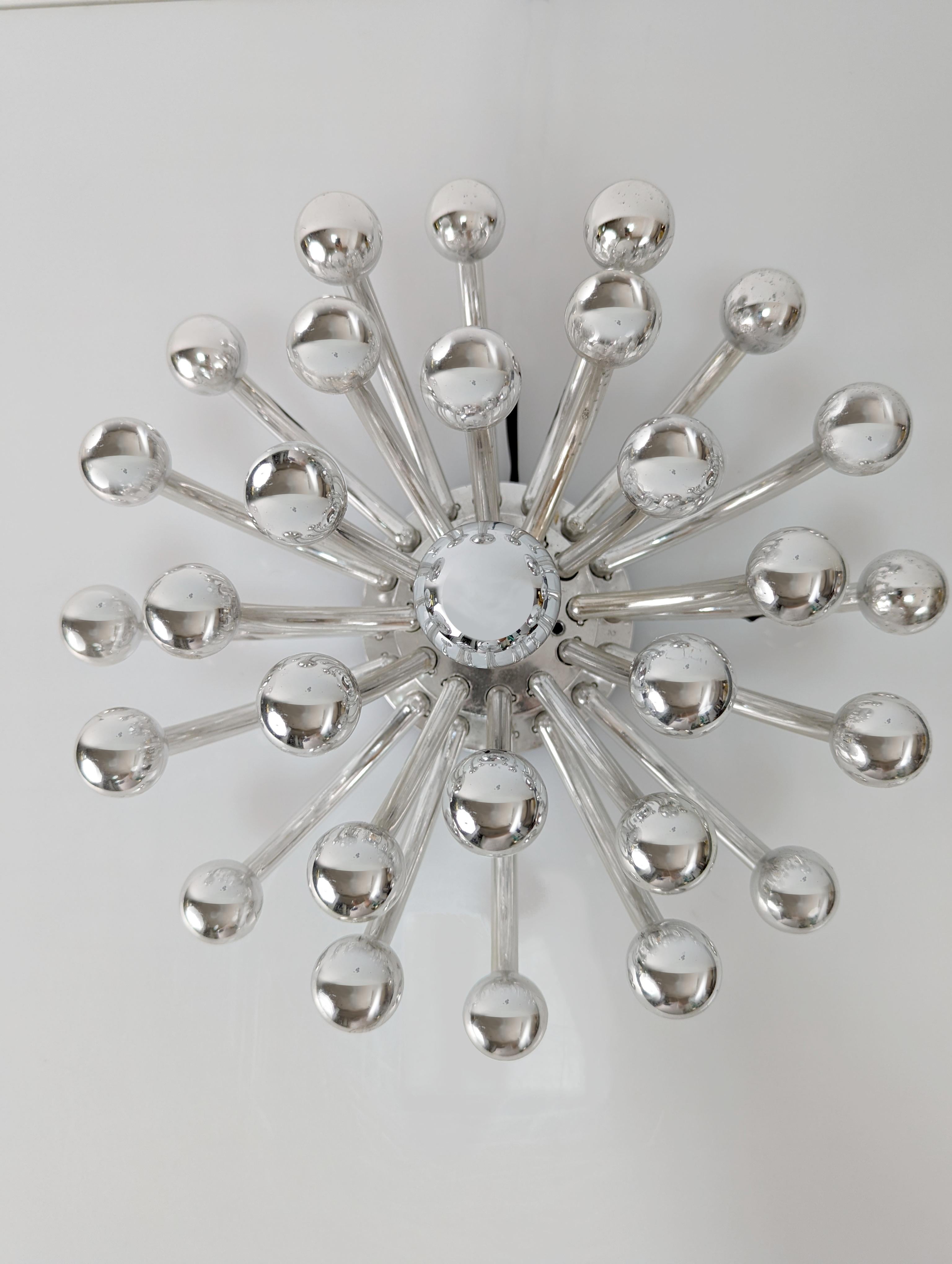 Preciosa lámpara “Pistillino” diseñada por Valenti Luce en los años 70, este icono de la iluminación se puede utilizar como lámpara de pared, de techo o de mesa para crear fantásticos juegos de luces.
