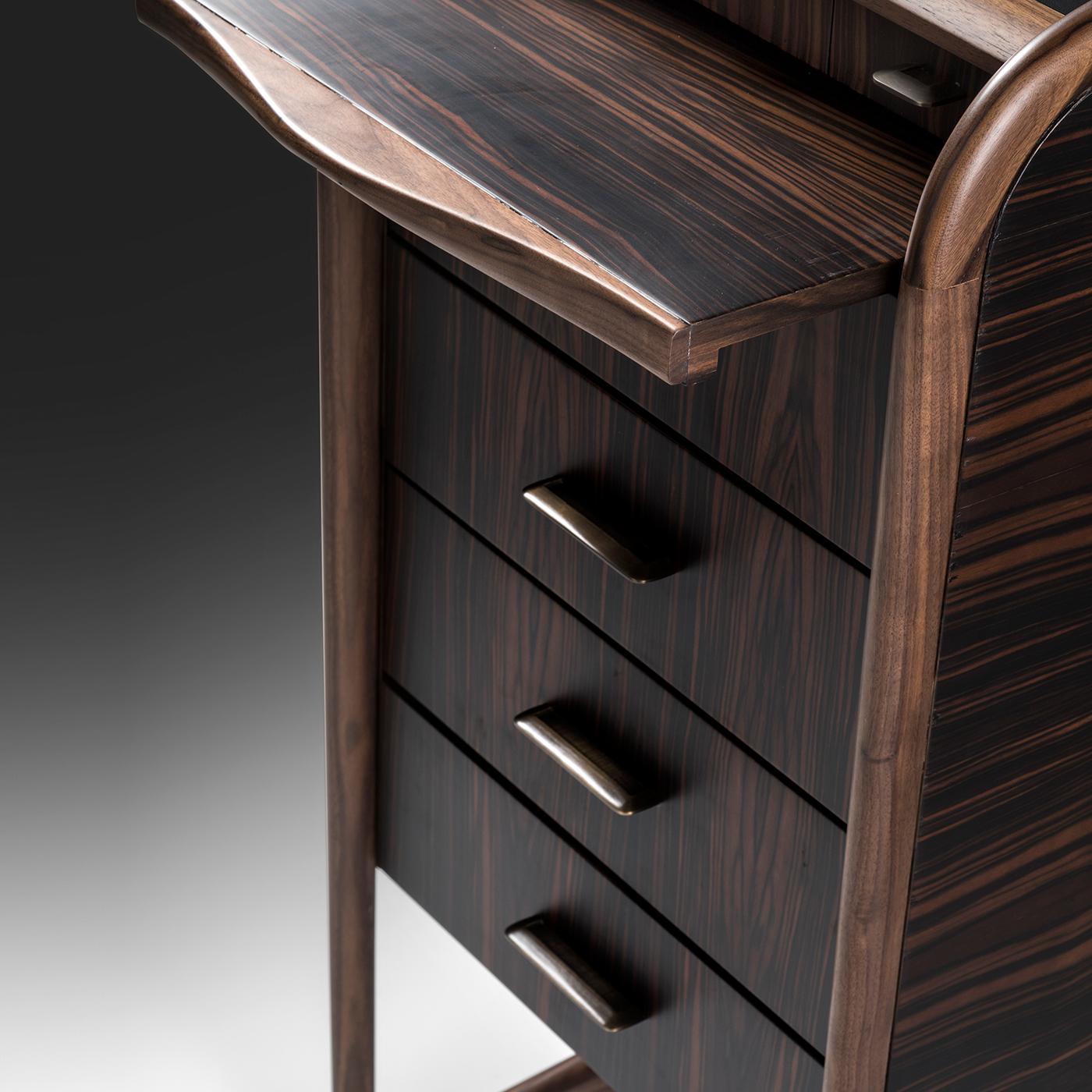 Lightweight and versatile, this fine chest of drawers is a sculptural piece providing a classic-inspired touch in any interior space. The ebony storage unit is organized in four large and three small drawers and is gracefully supported by a sinuous