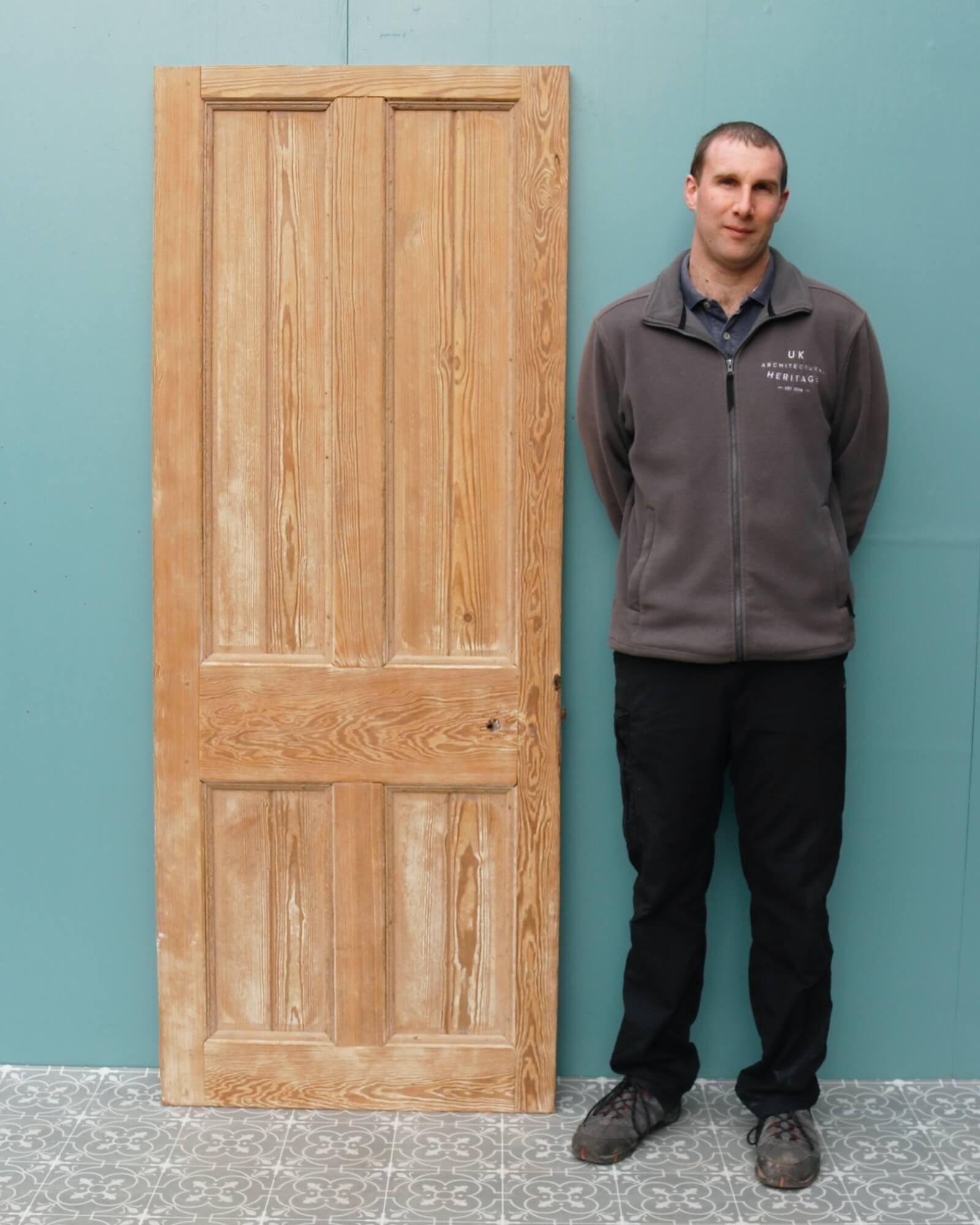 A sturdy pitch pine 4-panel door with a stripped finish. This reclaimed door is made from solid pitch pine that has a characteristic warm wood colour and attractive grain that looks handsome in any interior setting. It features 4 panels to both the