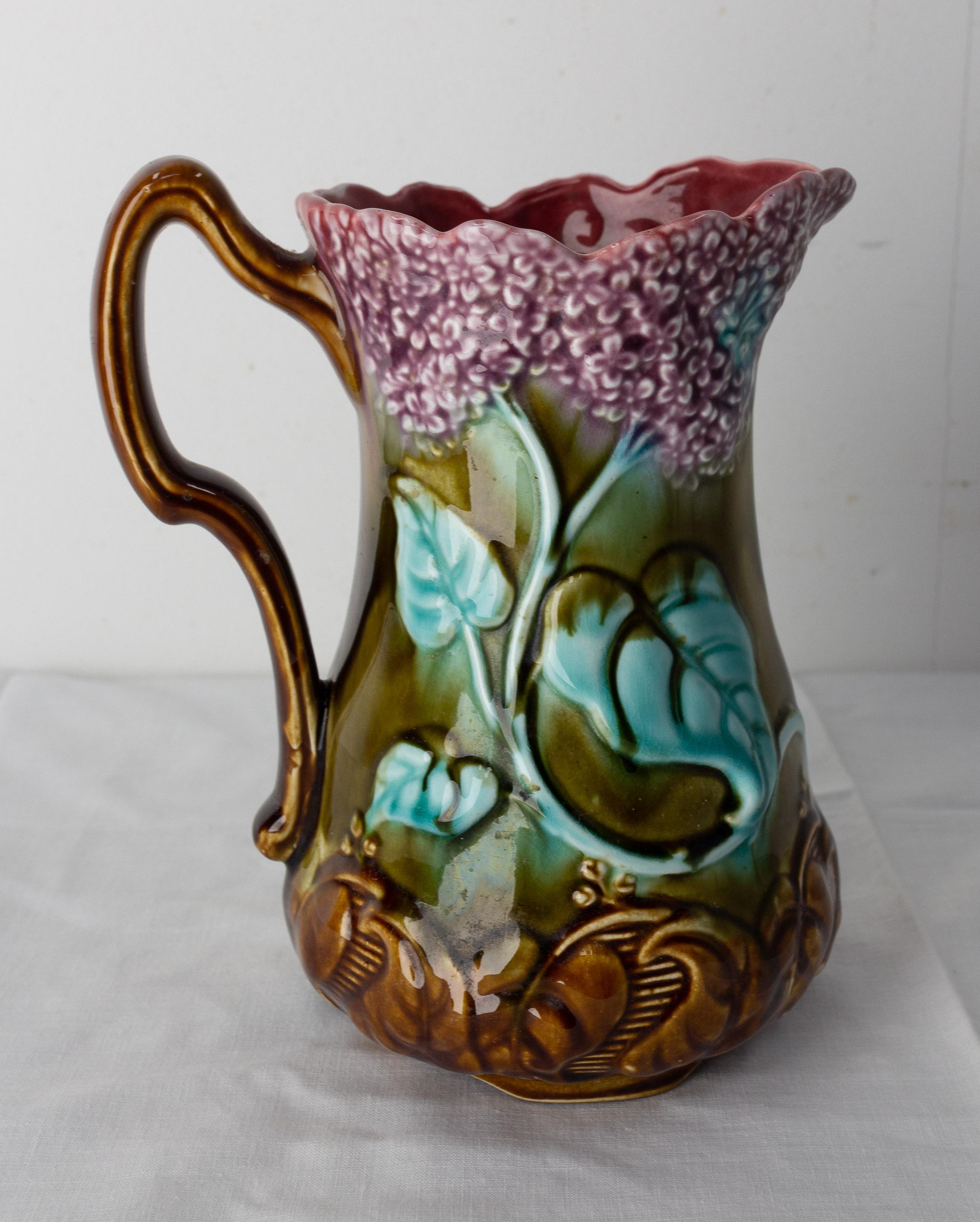 French Pitcher from Onnaing Manufactures, circa 1900.
Art nouveau
Barbotine faience pitcher with two purple lilac branches reprensented
Good condition

Shipping 
L17 P11 H19 0,680 Kg.