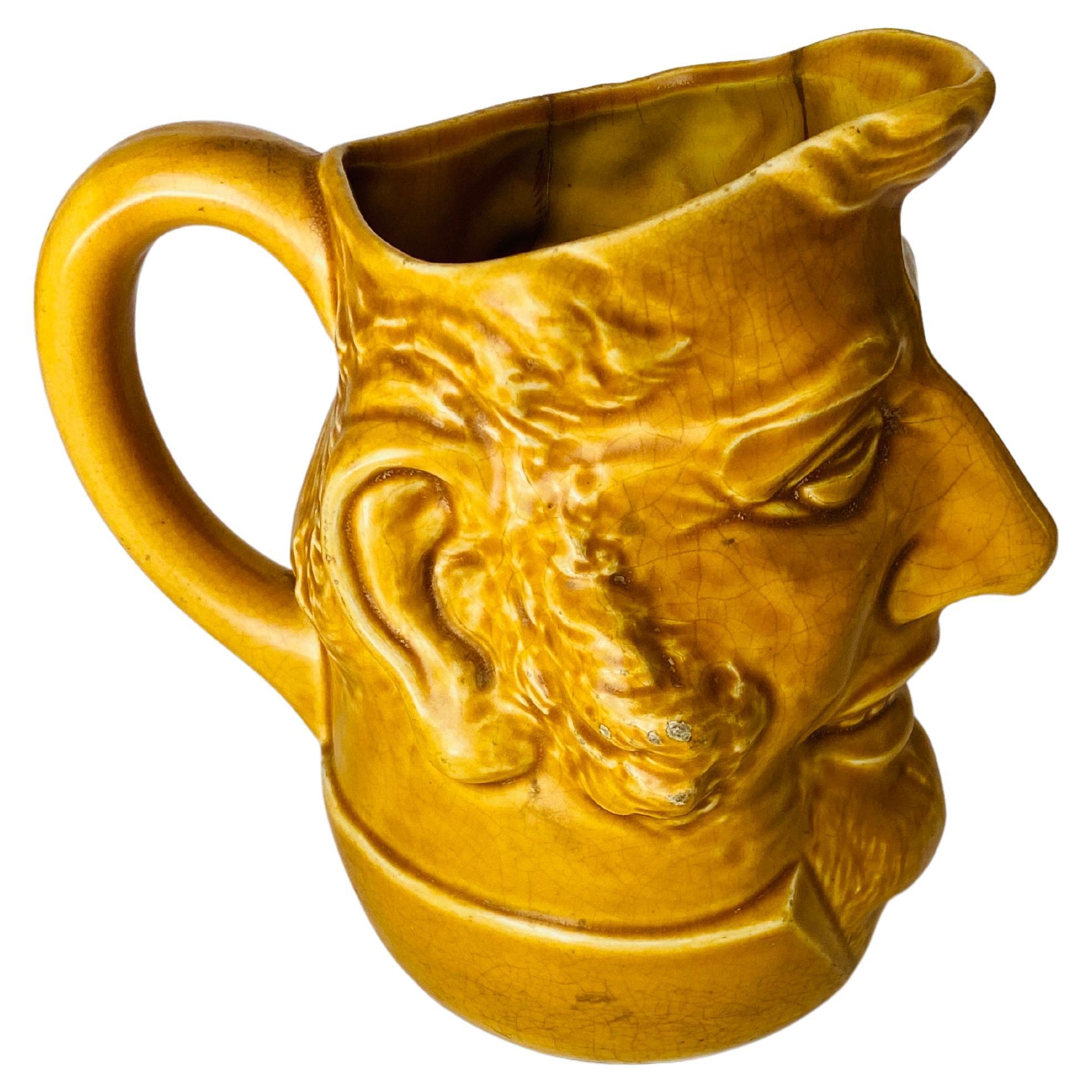 Esta Jarra es de cerámica, con una forma muy original.  Es de color Amarillo y se creó en la década de 1970 en Vallauris, Francia.
La forma es una Cara de Hombre.