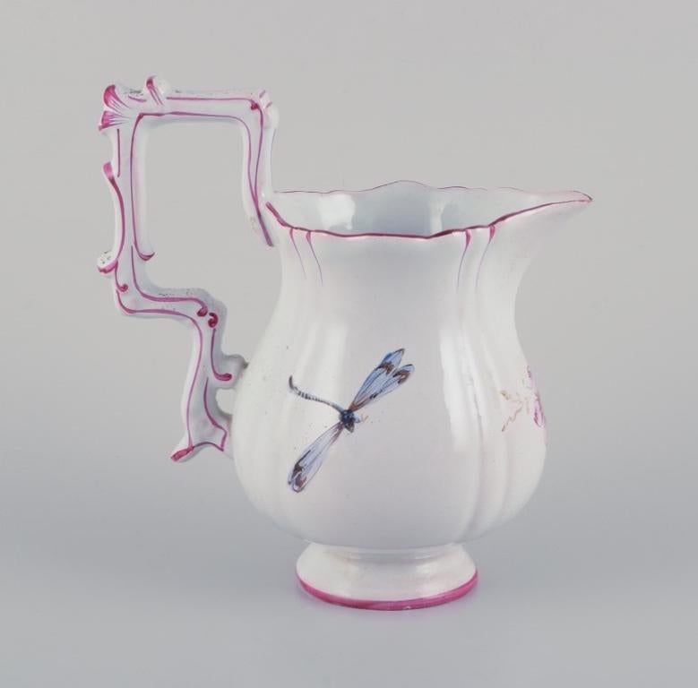 Pitcher in faience with motifs of flowers and insects. Style of Emile Gallé.
1870s.
Marked.
In good condition with small insignificant chips on the spout. See photo.
Dimensions: H 17.0 cm x W 16.0 cm x D 10.0 cm.
