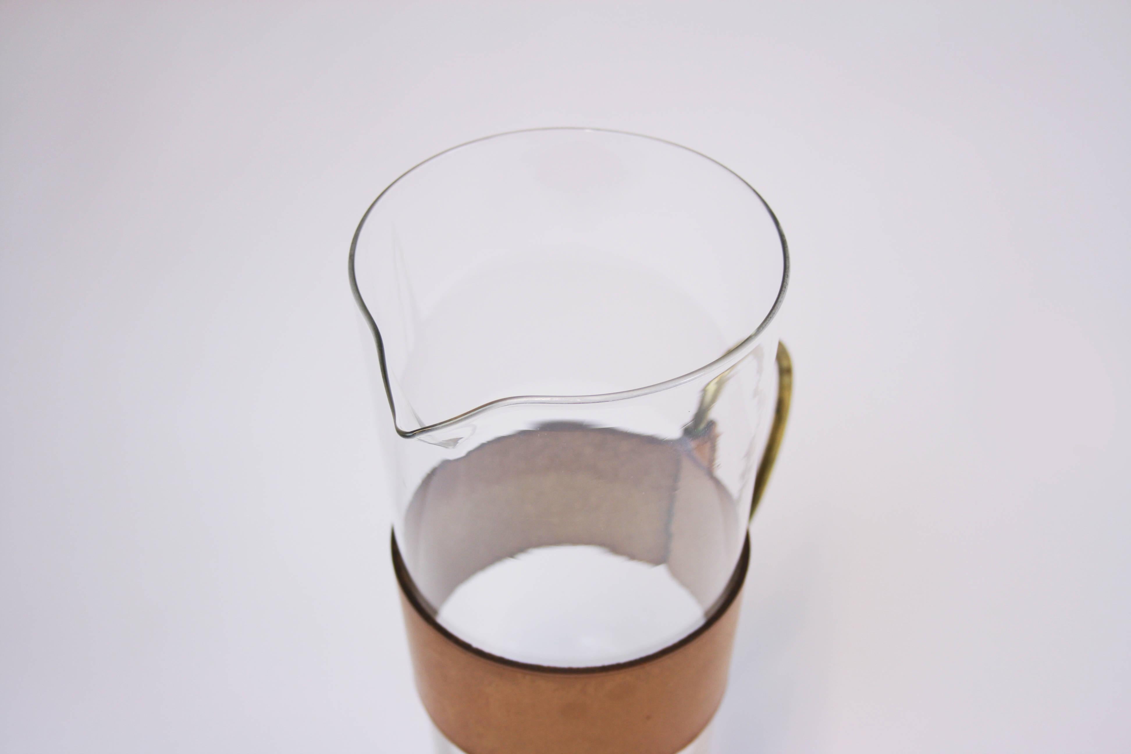 Krug oder Wasserkrug Messing-Leder-Glas Werkstätte Carl Auböck Wien 1950er Jahre. Ein seltenes und kostbares Objekt in hervorragendem Originalzustand, das ein Schmuckstück für jede Sammlung werden kann. Das in den späten 1950er Jahren hergestellte