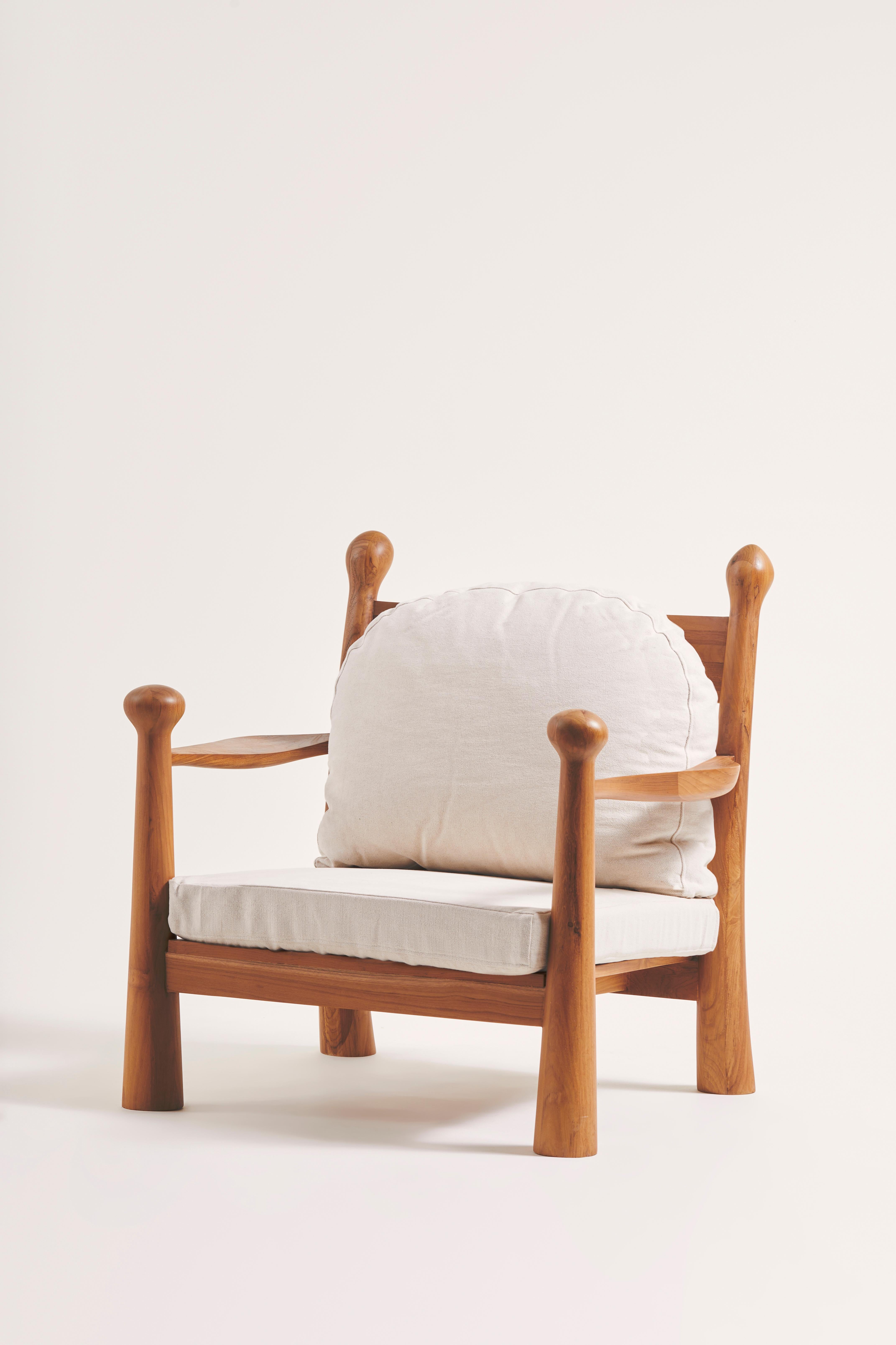 Embrace the unique allure of the Pitufi Lounge Chair, a masterpiece of asymmetry and artisan craftsmanship. Hand-carved from teak wood and detailed with intricate rope work, it’s designed for durability and comfort in outdoor settings, enhanced by