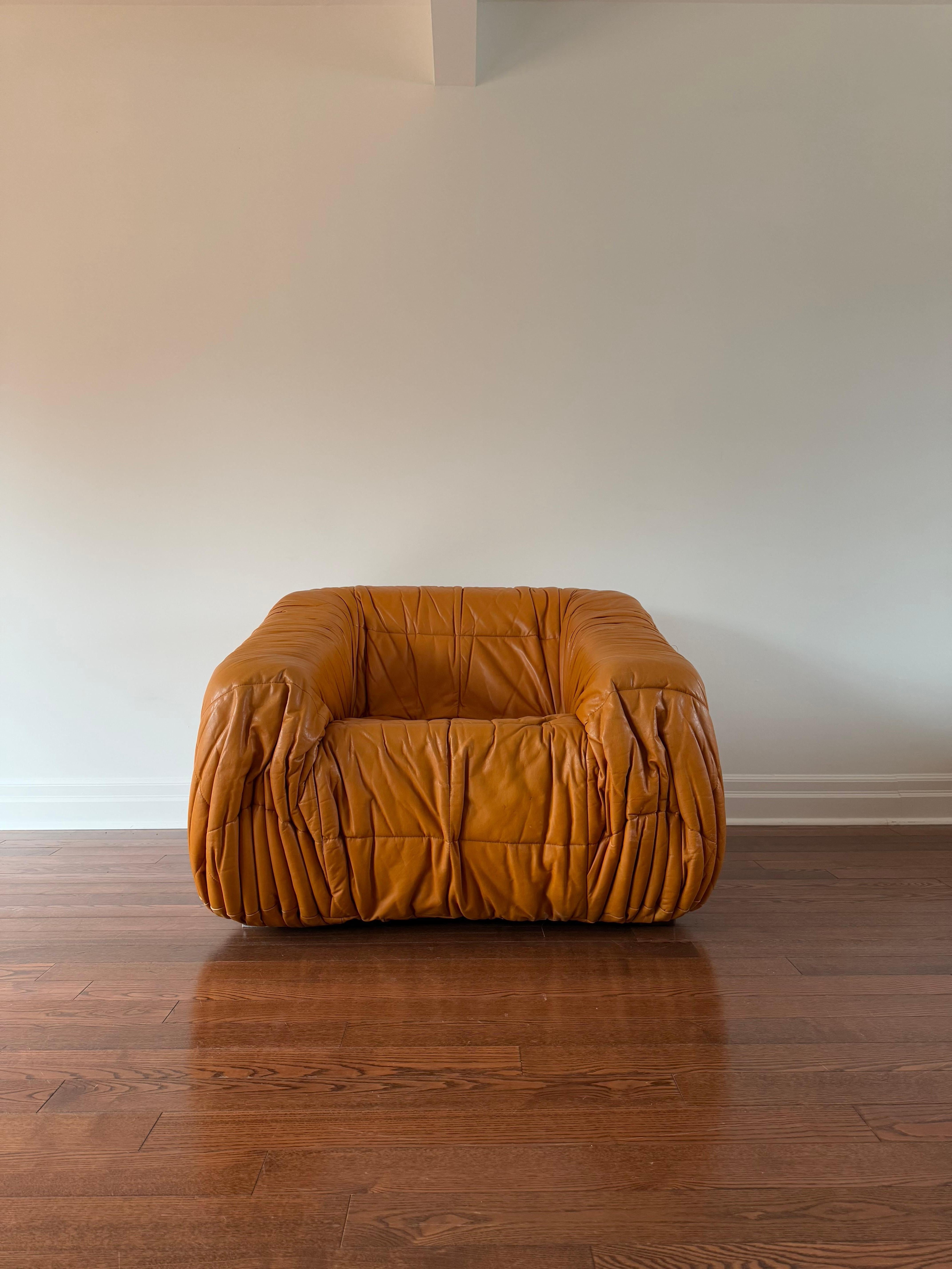 Piumino armchair in original pleated leather upholstery. Both foam construction and leather are in great condition. Original tag was cut but is still visible front right of sofa [pictured].

Iconic and rare Italian design by Milanese architects De