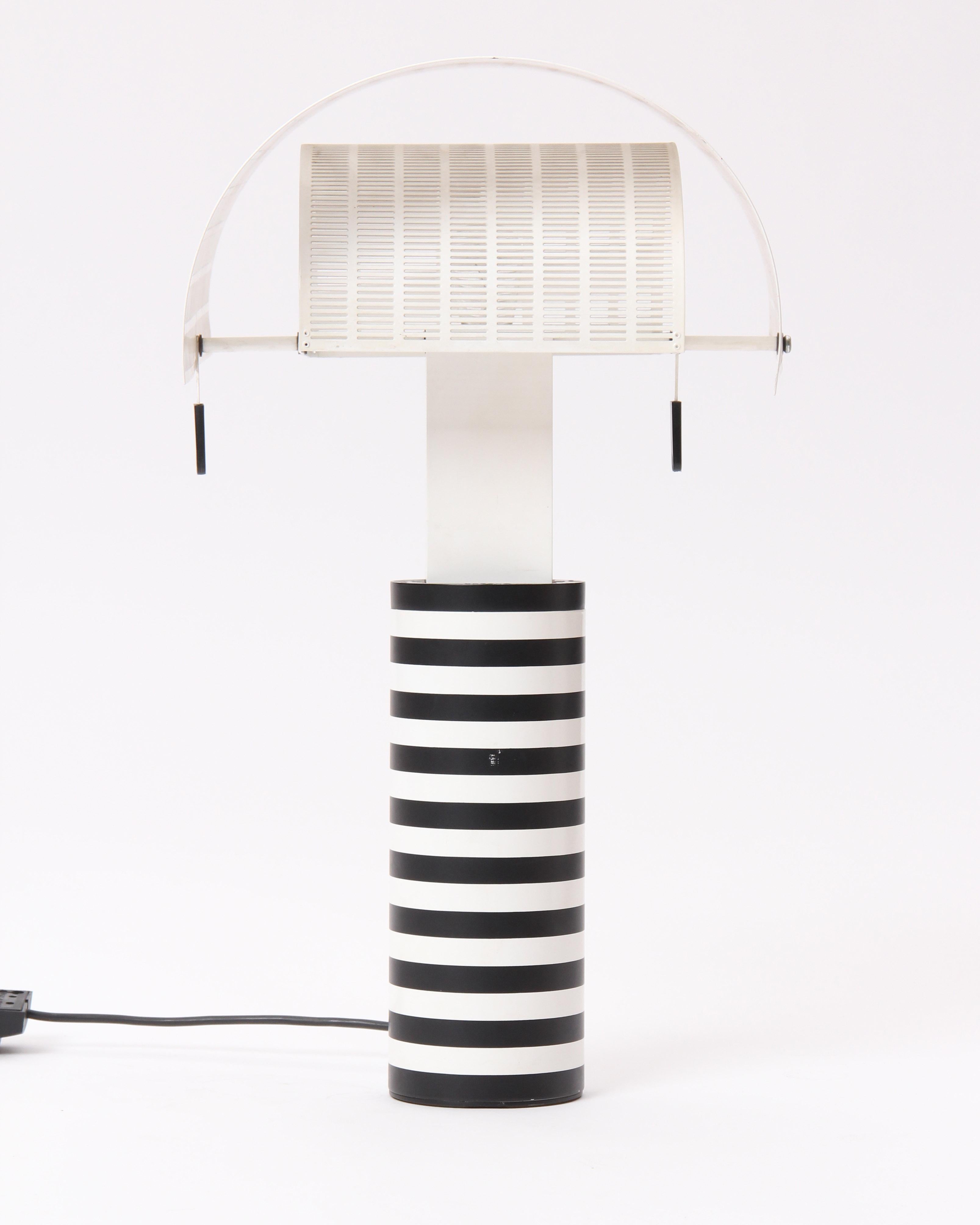 A 'Shogun' table lamp designed by Mario Botta with pivoting, slit-perforated white steel shades on a black and white striped cylinder base. Made by Artemide in Italy, circa 1986.