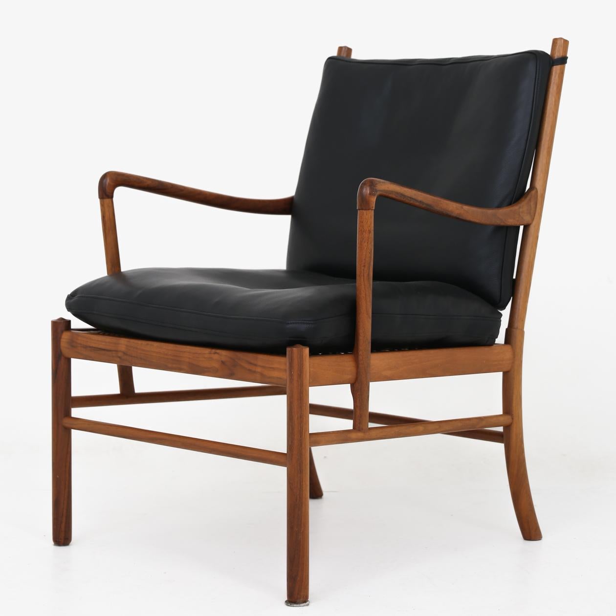 Colonial chair with matching footstool in walnut and black leather. By Ole Wanscher / P.J Furniture