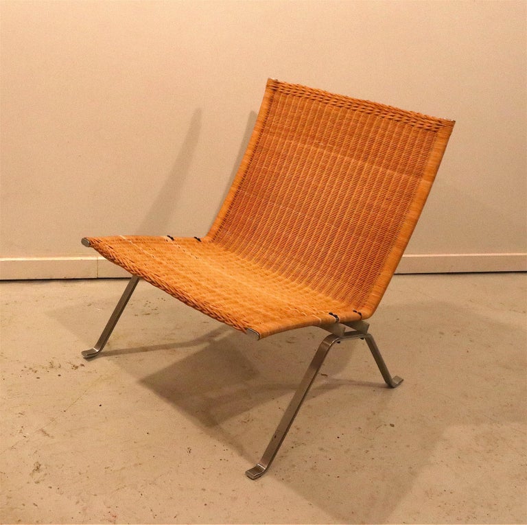 Early 1980's vintage easy chair PK22 designed by Poul Kjaerholm in hand-woven rattan and brushed steel. The chair is in excellent condition, with some patina to the frame according to the age; which only enhances the character of the chair. The