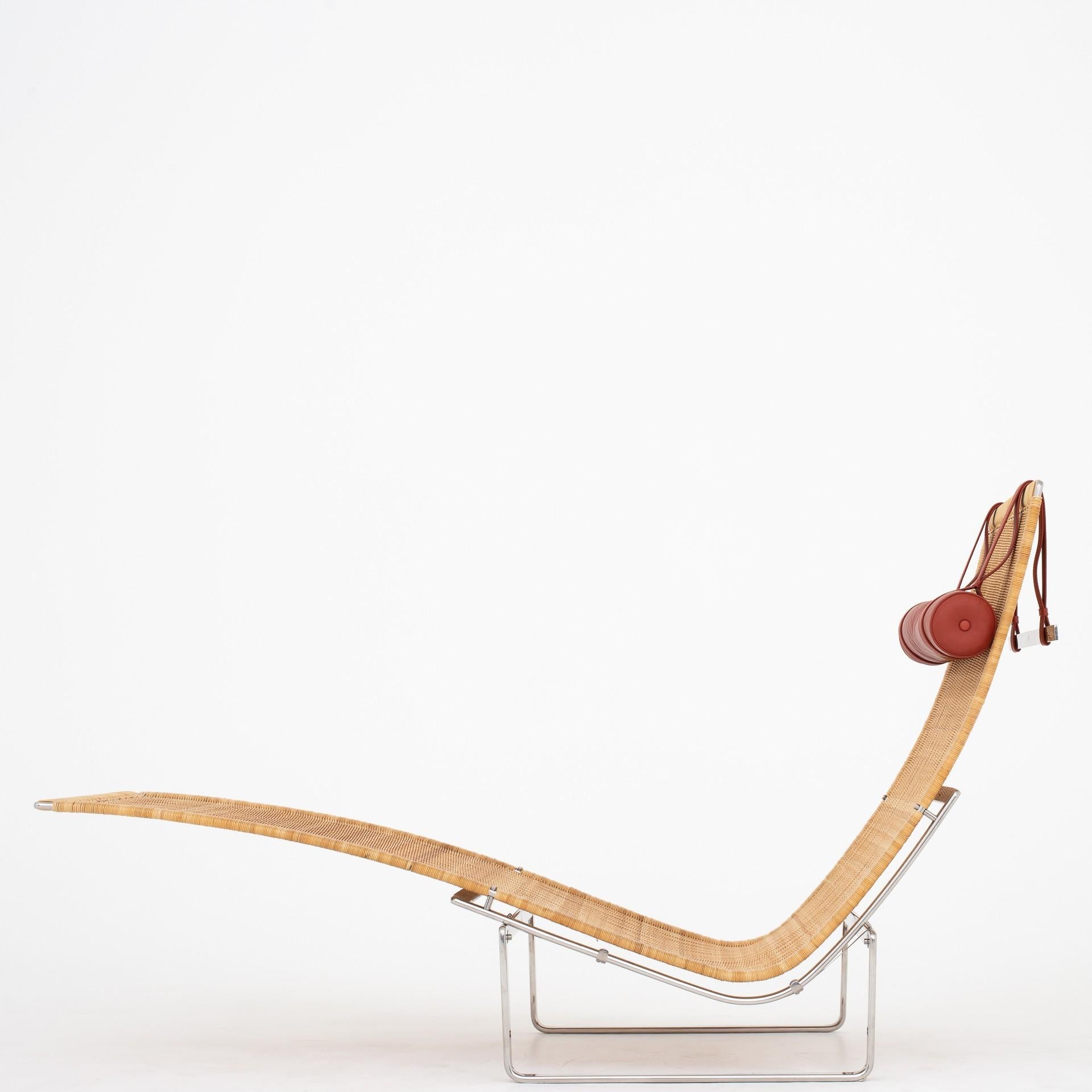 PK 24 - chaise lounge in cane on a steel frame. Neck pillow in red leather. Maker Fritz Hansen.