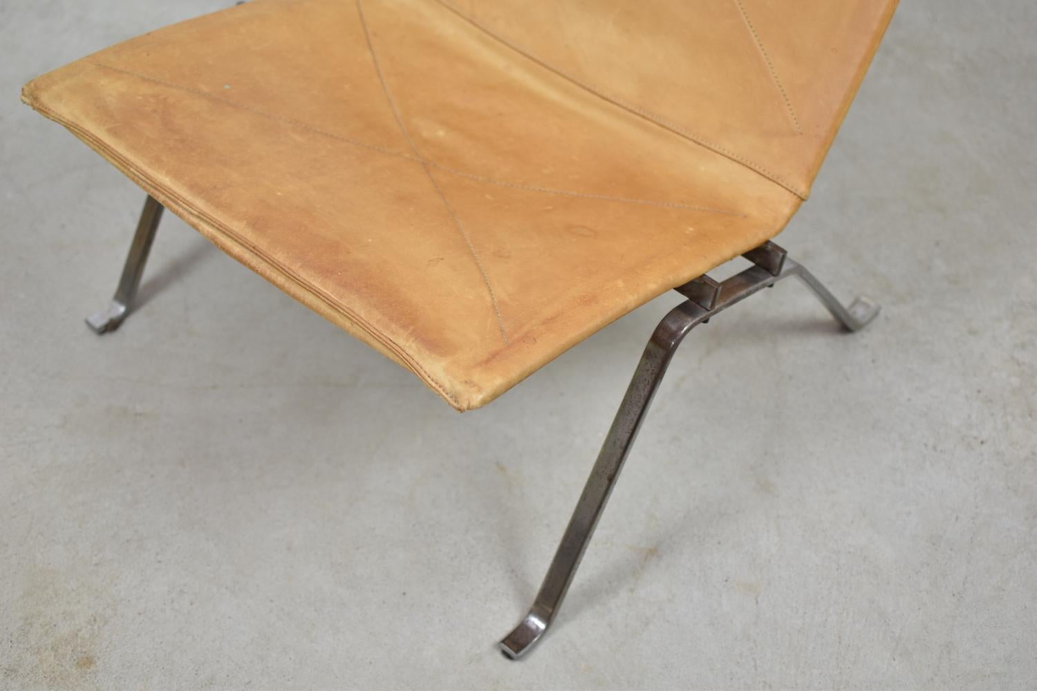 Original first edition PK22 easy chair designed by Poul Kjaerholm for E. Kold Christensen, Denmark 1956. This stunning piece got its original naturel leather upholstery and a matte chromed flat steel base. Marked in the frame underneath the seat