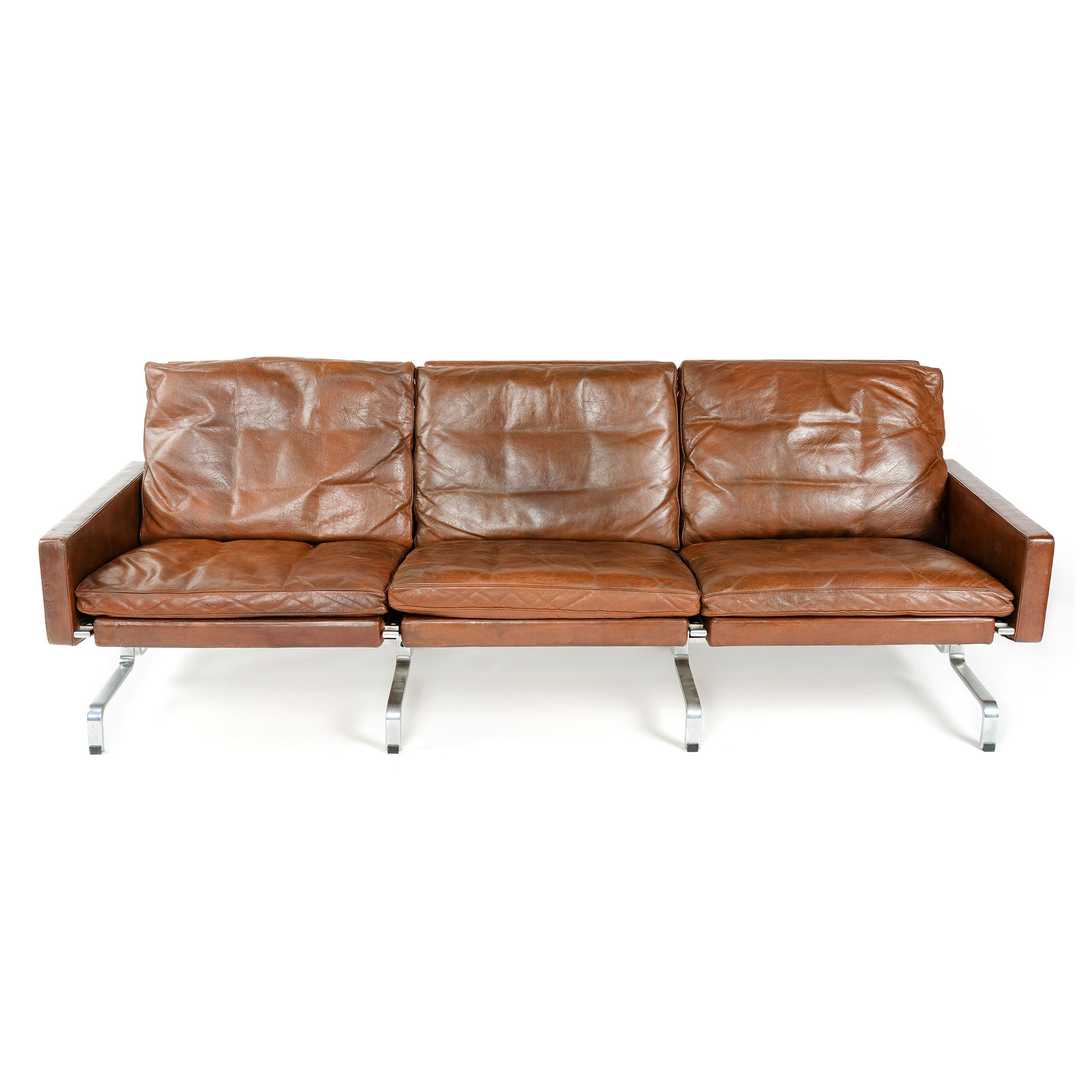 A 'PK31-3' three-seat sofa with a stainless steel frame; retaining the original brown leather upholstery.