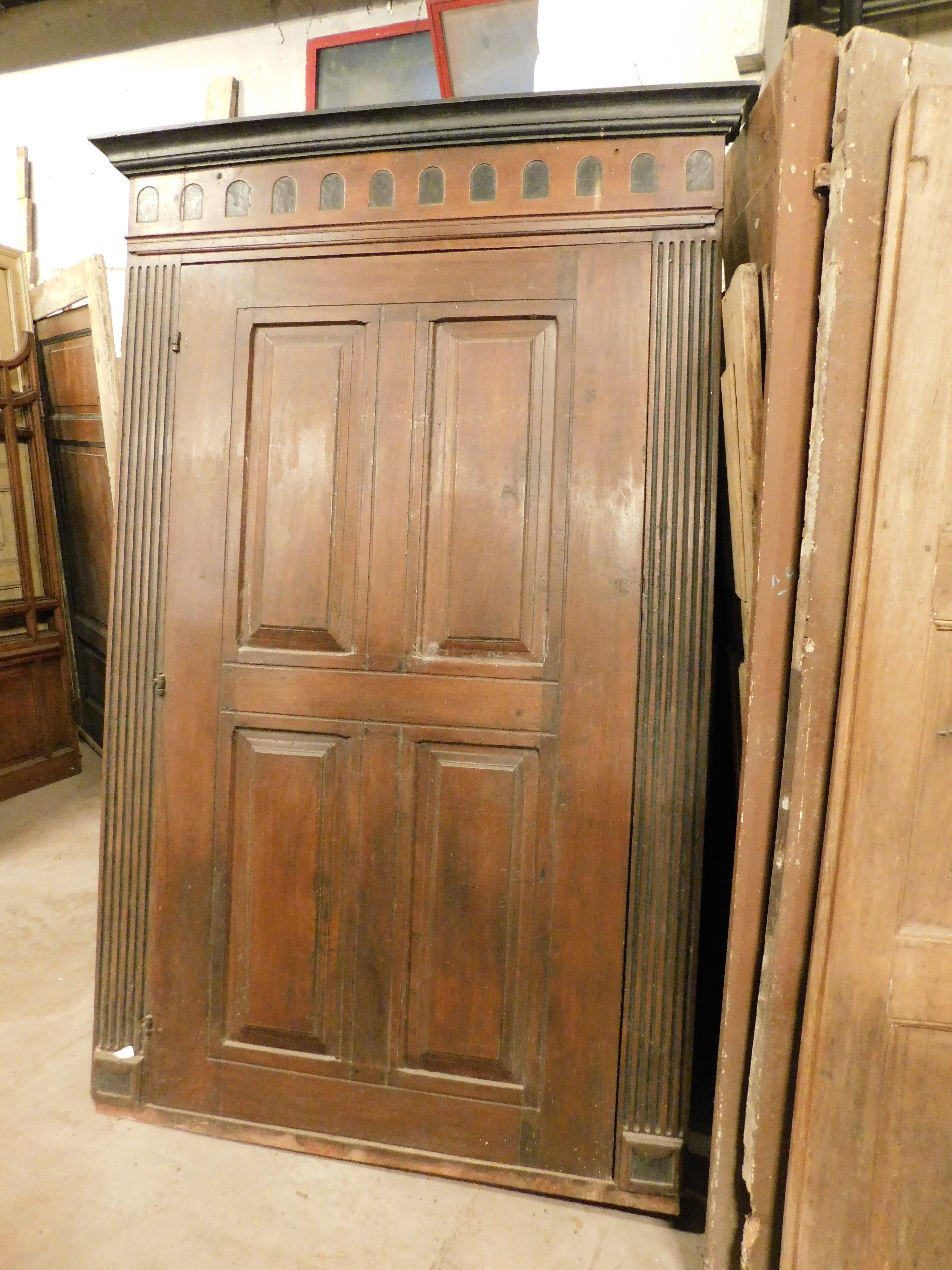 Cartellone antico, facciata, porta a un'anta, riccamente intagliato in stile impero con cornice originale, dettagli neri piegati come le colonne laterali, costruito in legno massiccio e massello di noce, ha un'apertura a sinistra a strappo,