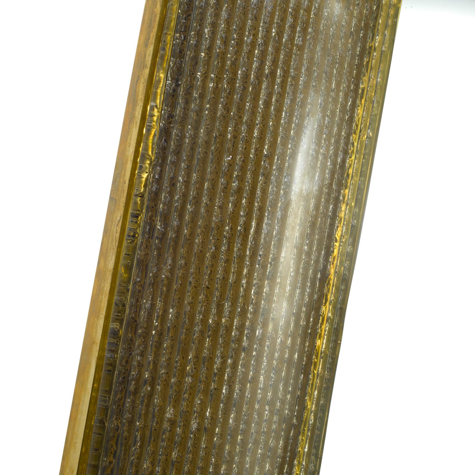 Der in Italien hergestellte Spiegel Placche besteht aus geschwungenen Muranoglasplatten, die mit Messingbeschlägen in einem Rahmen aus natürlichem Messing befestigt sind. Wir verwenden drei verschiedene Glastexturen - säuregeätztes 