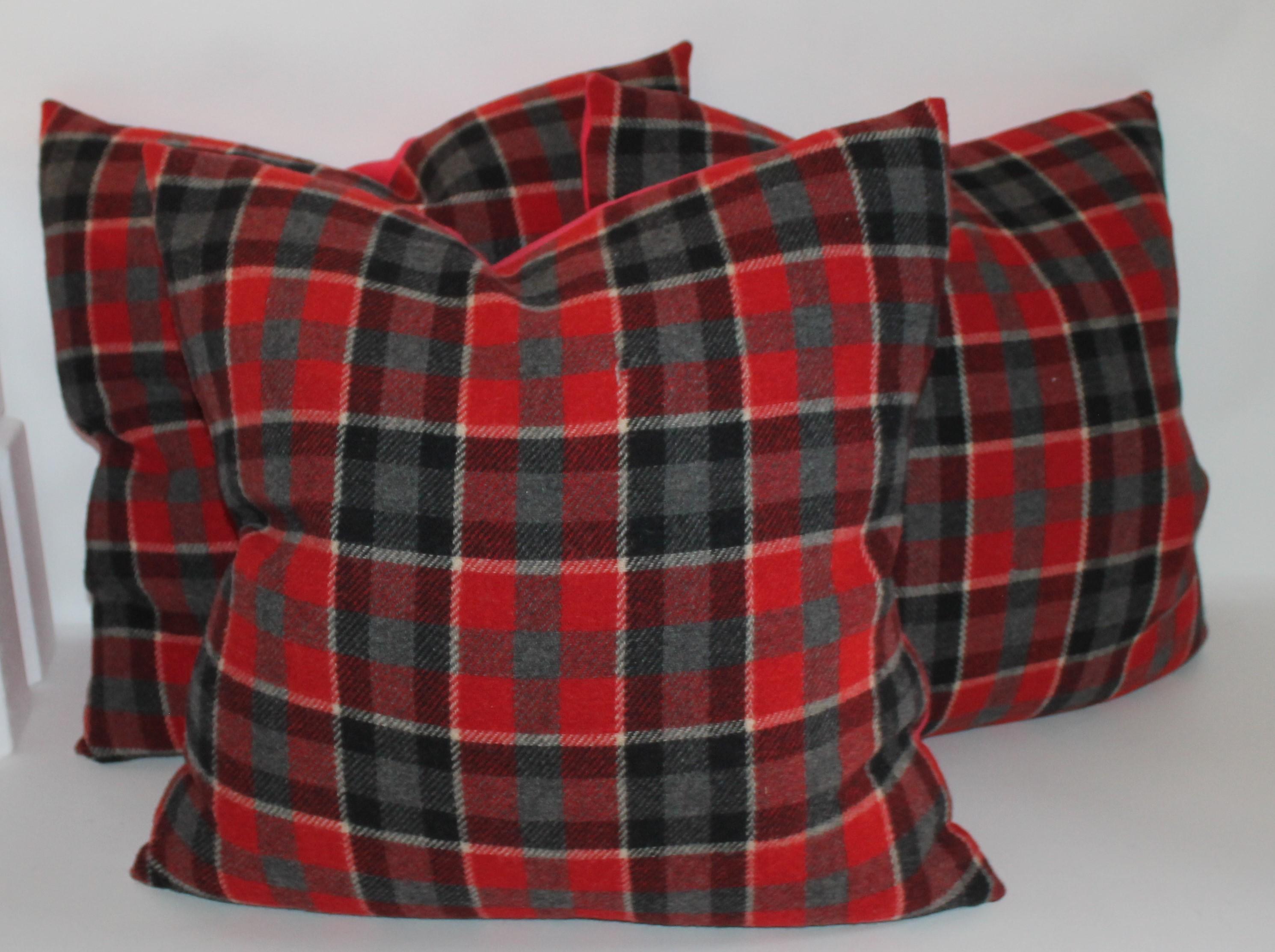 We have two different styles and colors of holiday plaids. There are burnt orange and black wool plaid pillows. There are two pairs of these in stock. All in pristine condition with black cotton linen backings.
The next colors are black and red and