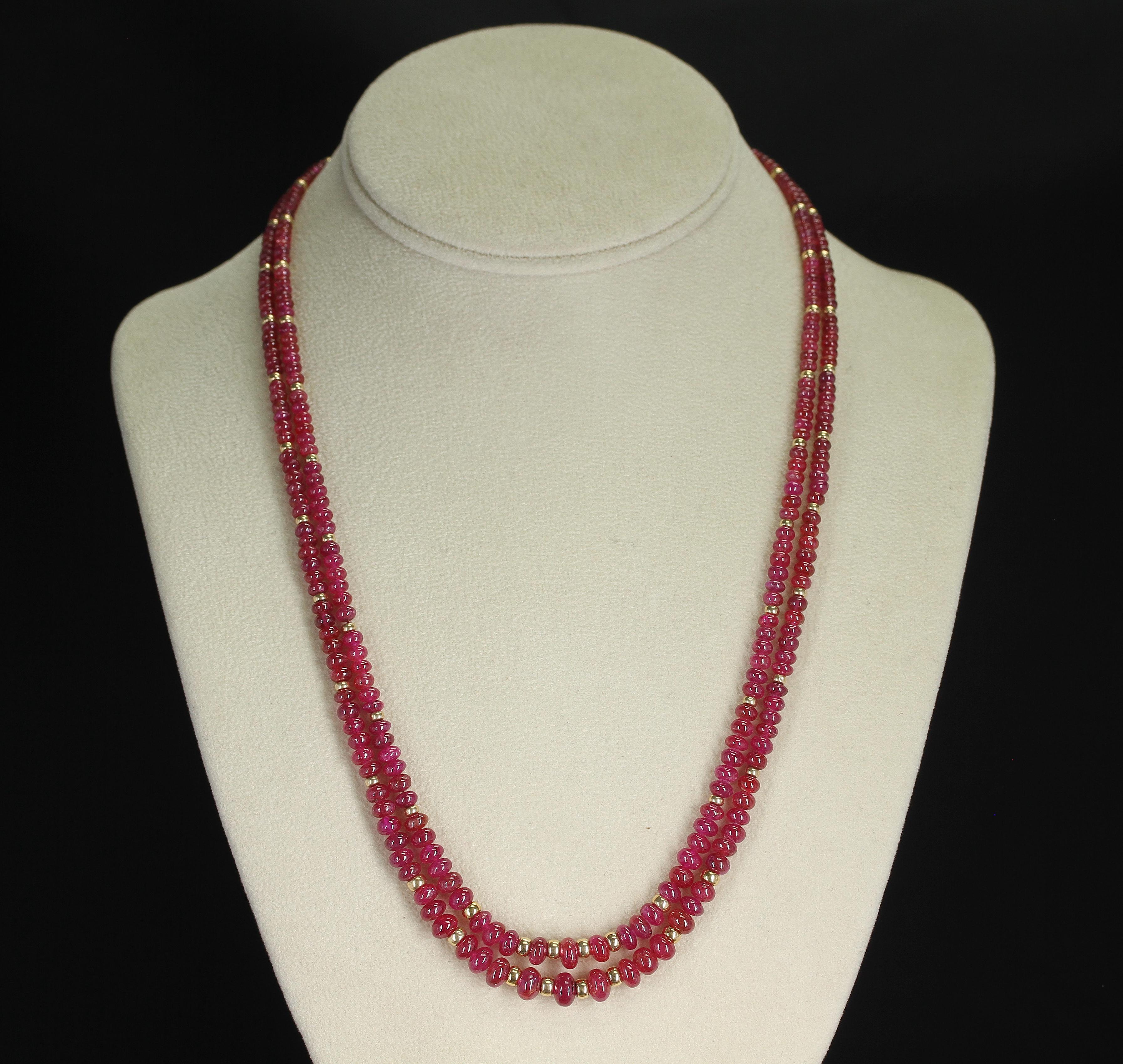 A necklace consisting of two strands of smooth & plain Ruby beads with 14K Gold Beads. The beads range from 2.5MM to 7MM and weigh a total of 184 carats. The clasp is 14K Yellow Gold.