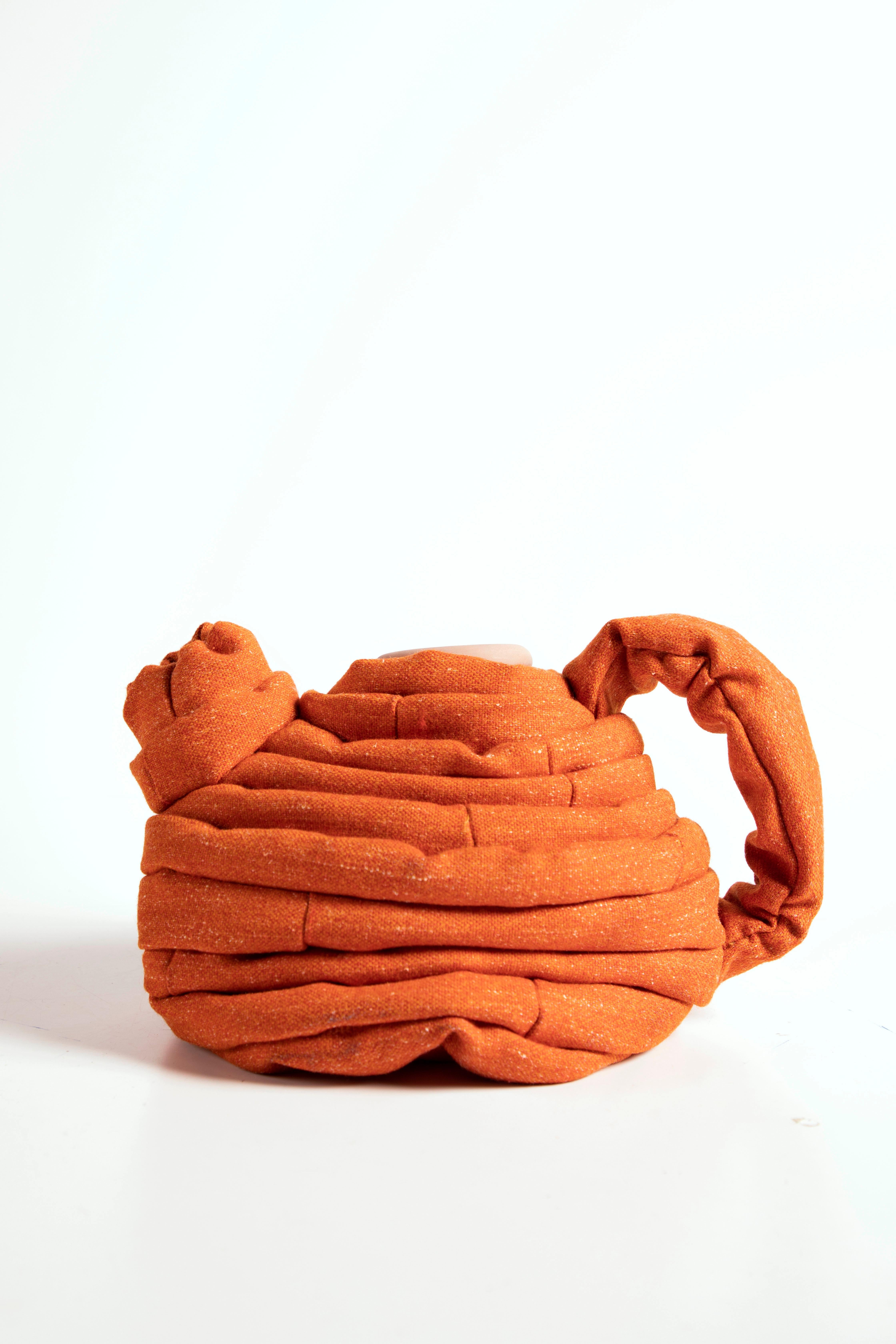 Plakkenpot E coffee pot by Hanna Kooistra
Dimensions: 23 x 25 cm
Materials: ceramics, wool.

These coffee pots are a reinterpretation of a coffee pot from the Rijksmuseum. The view of this pre-industrial object transform trough a dynamic design