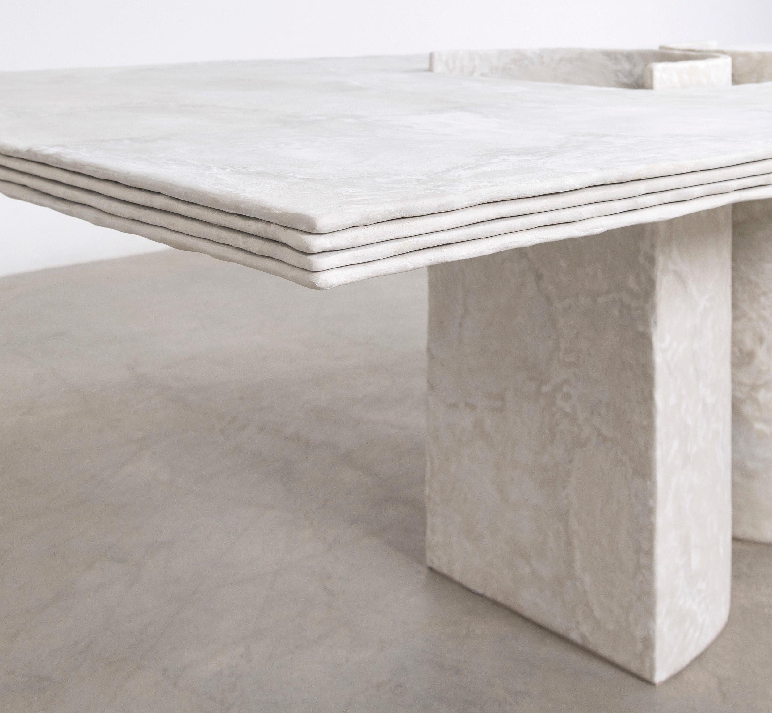 This rectangular dining table is furniture as sculpture, hand-crafted from cement by emerging artist Bailey Fontaine. Each table is unique, featuring the organic marks left by the artist during the sculpting process. It is a gorgeous minimalist