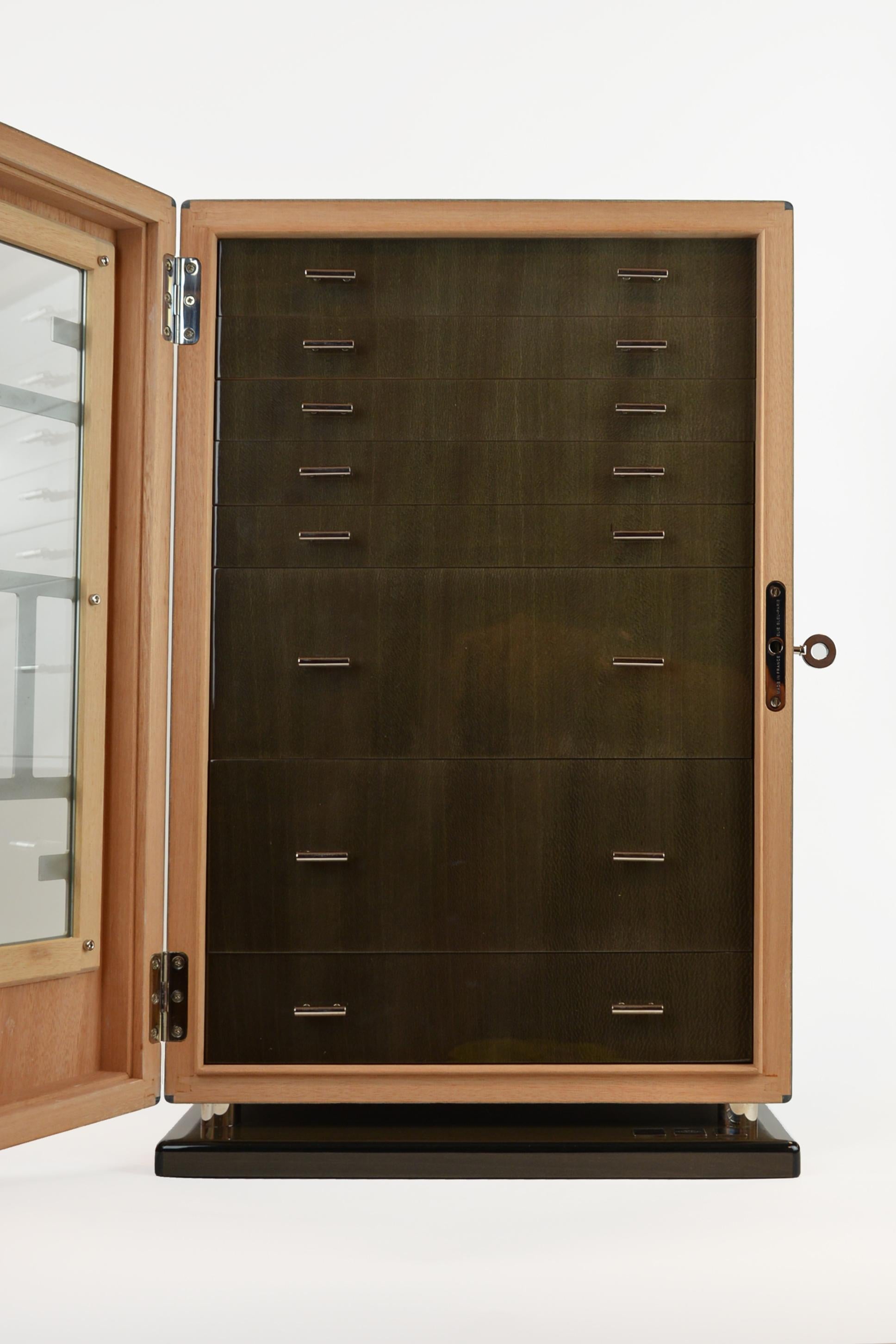Wooden jewelry cabinet with glass door and drawers.