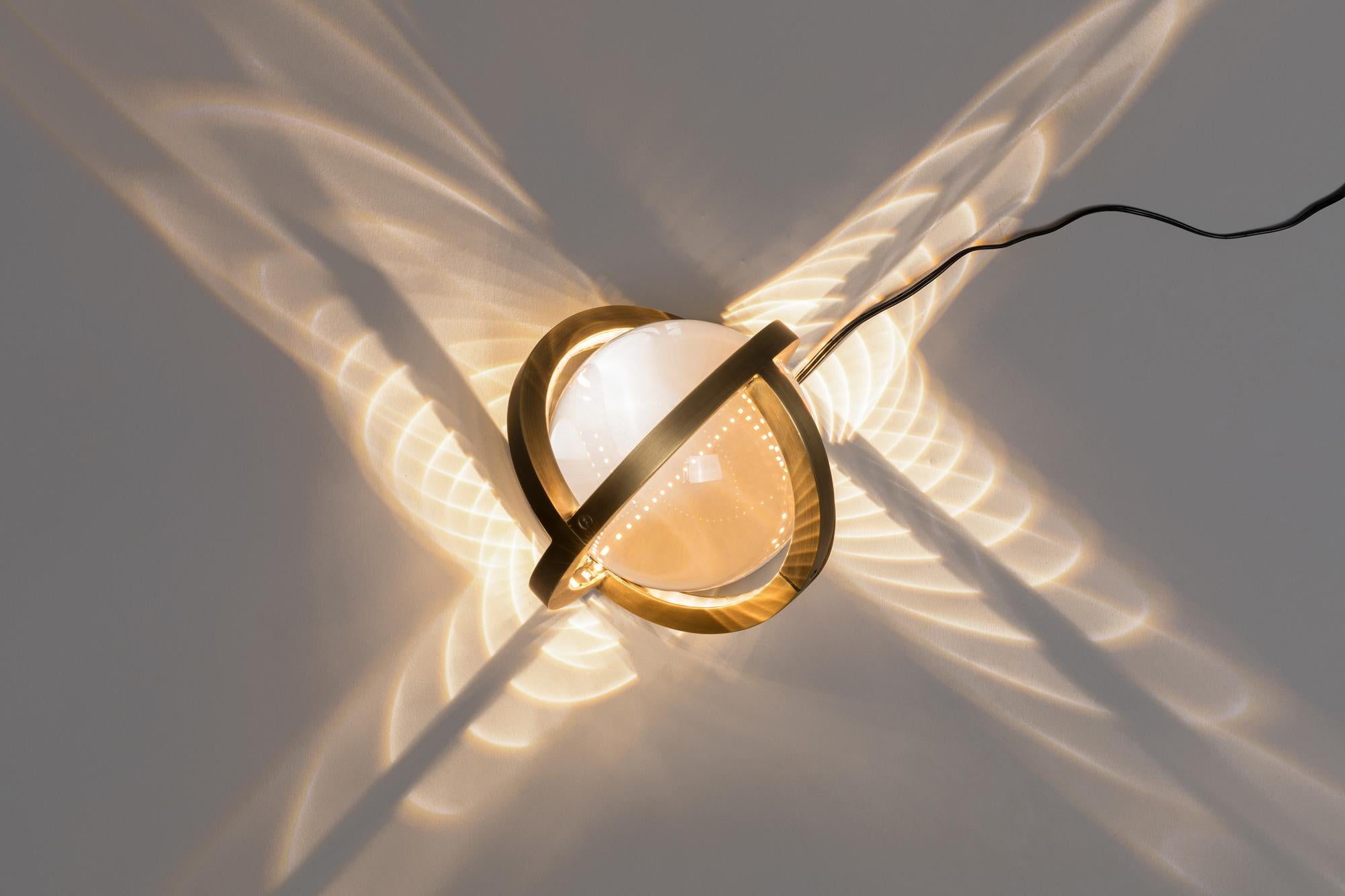 The new Planetaria lights are both geometric and organic. The lights rep-resent an exploration of the globe; one created by folding and rotating three flat circles to create a single sphere, which itself encases a reflective glass orb. The seed pod