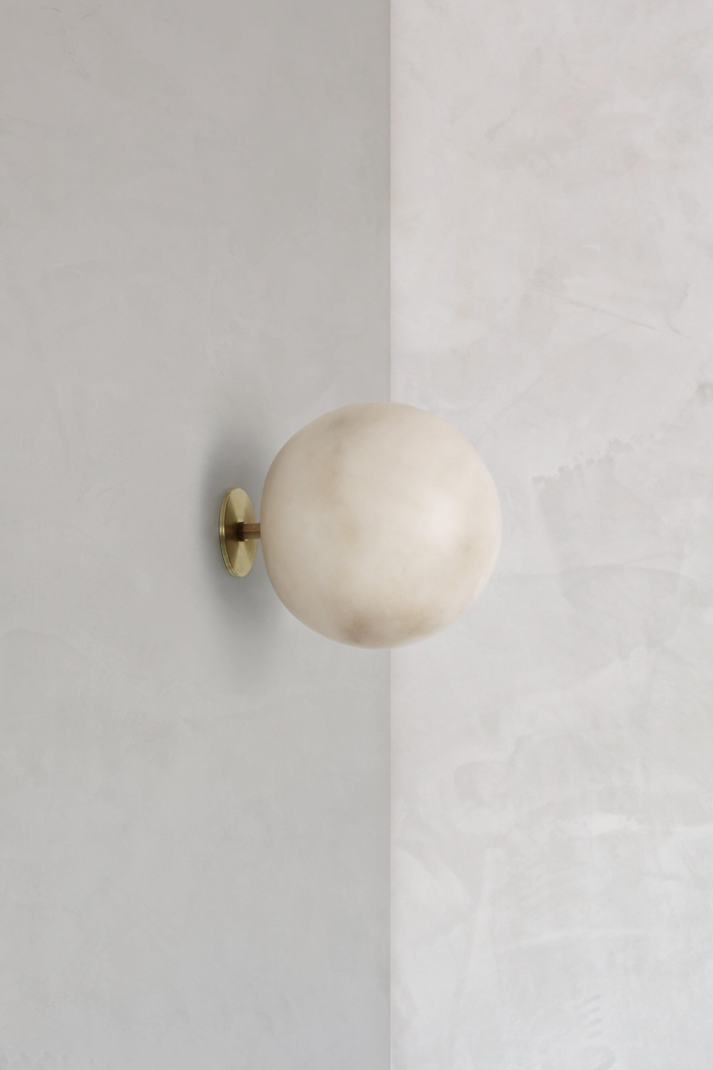 Planette wall 12 alabaster wall light by Contain.
Dimensions: D 12 x H 20 cm.
Materials: alabaster, brass
Also available in different finishes and dimensions (Ø12 cm / Ø16,5 cm / Ø18cm). 

All our lamps can be wired according to each country. If